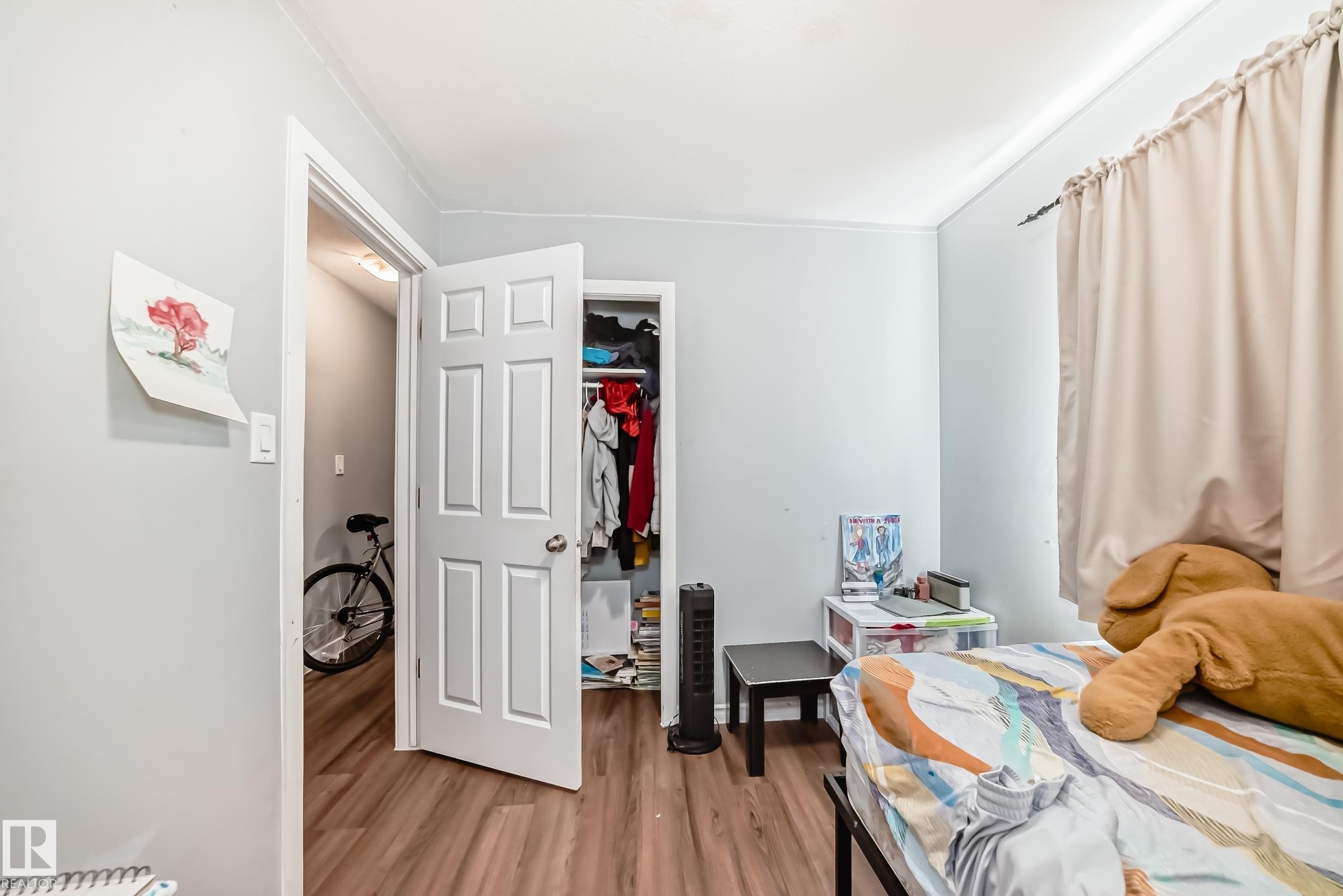 Room featuring wood-finish flooring, light blue wall paint, and white trim - 10017 153 Street, Edmonton, AB - Indoor Photo Showing Bedroom