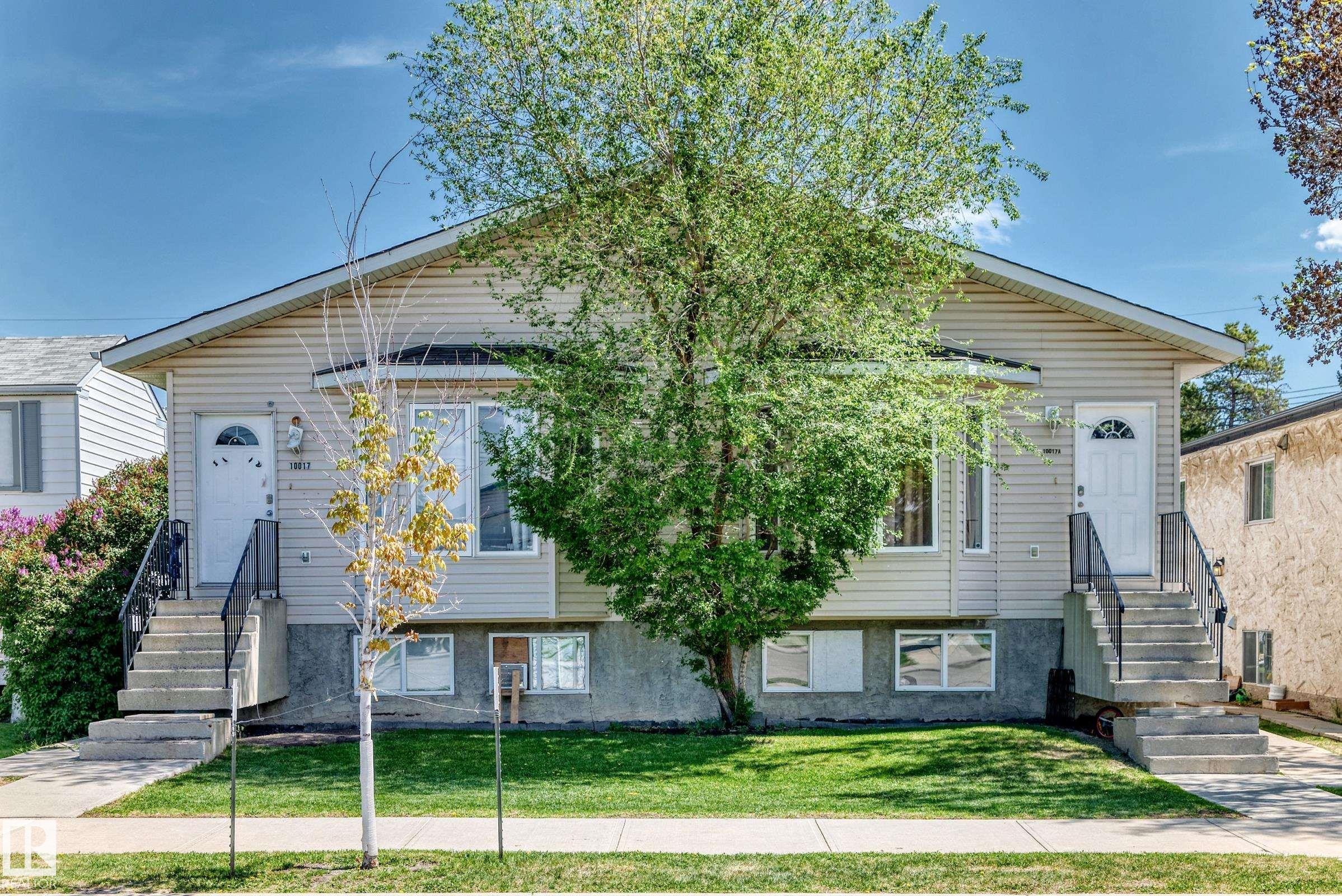 Duplex property featuring light-toned horizontal siding, a gabled roofline, and two separate entrances - 10017 153 Street, Edmonton, AB - Outdoor With Facade