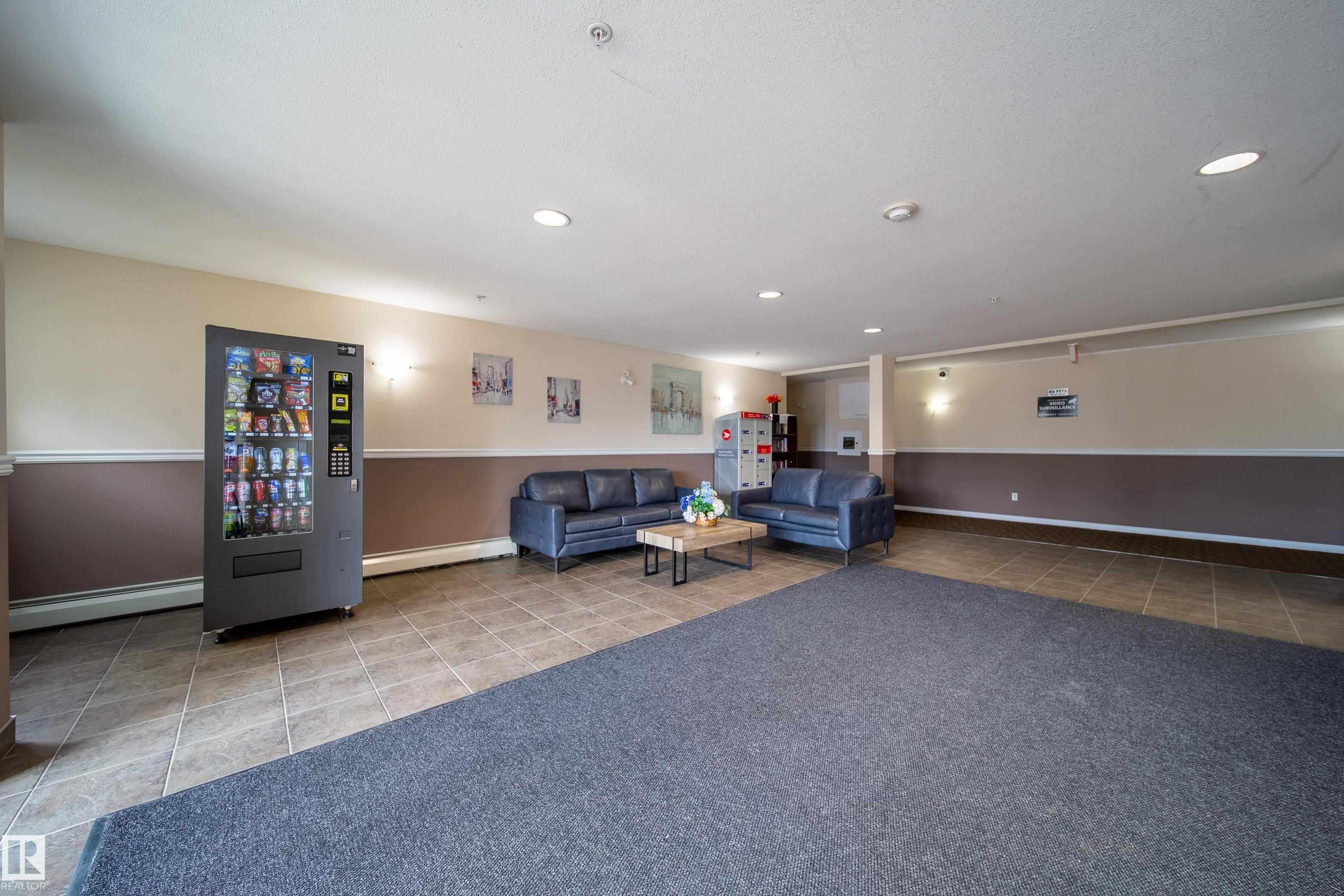 Lounge area featuring ceramic tile flooring, two-tone wall paint, recessed lighting, and a carpeted entry - 115 4309 33 Street, Stony Plain, AB