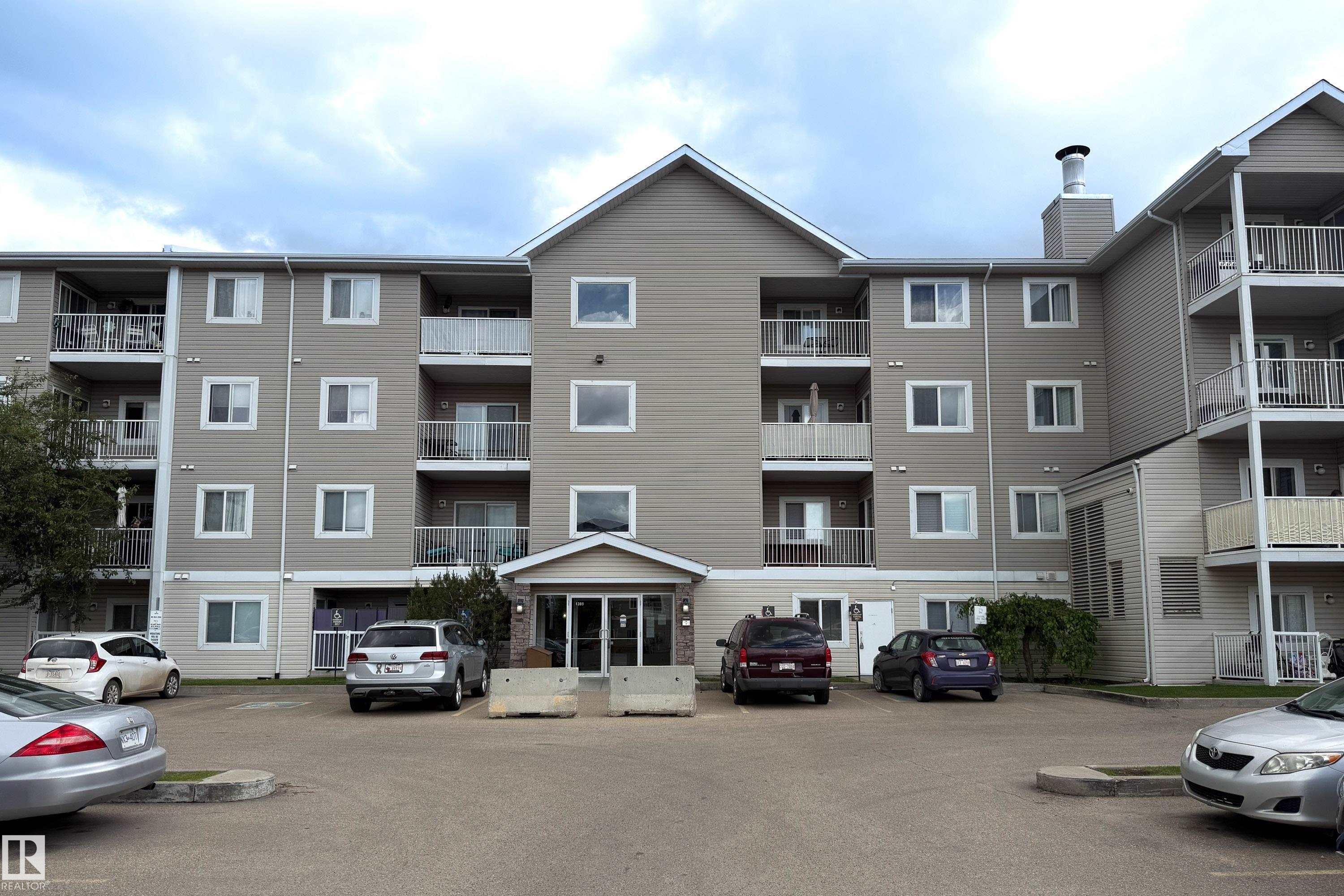 Multi-story apartment building with beige horizontal siding and white trim - 115 4309 33 Street, Stony Plain, AB