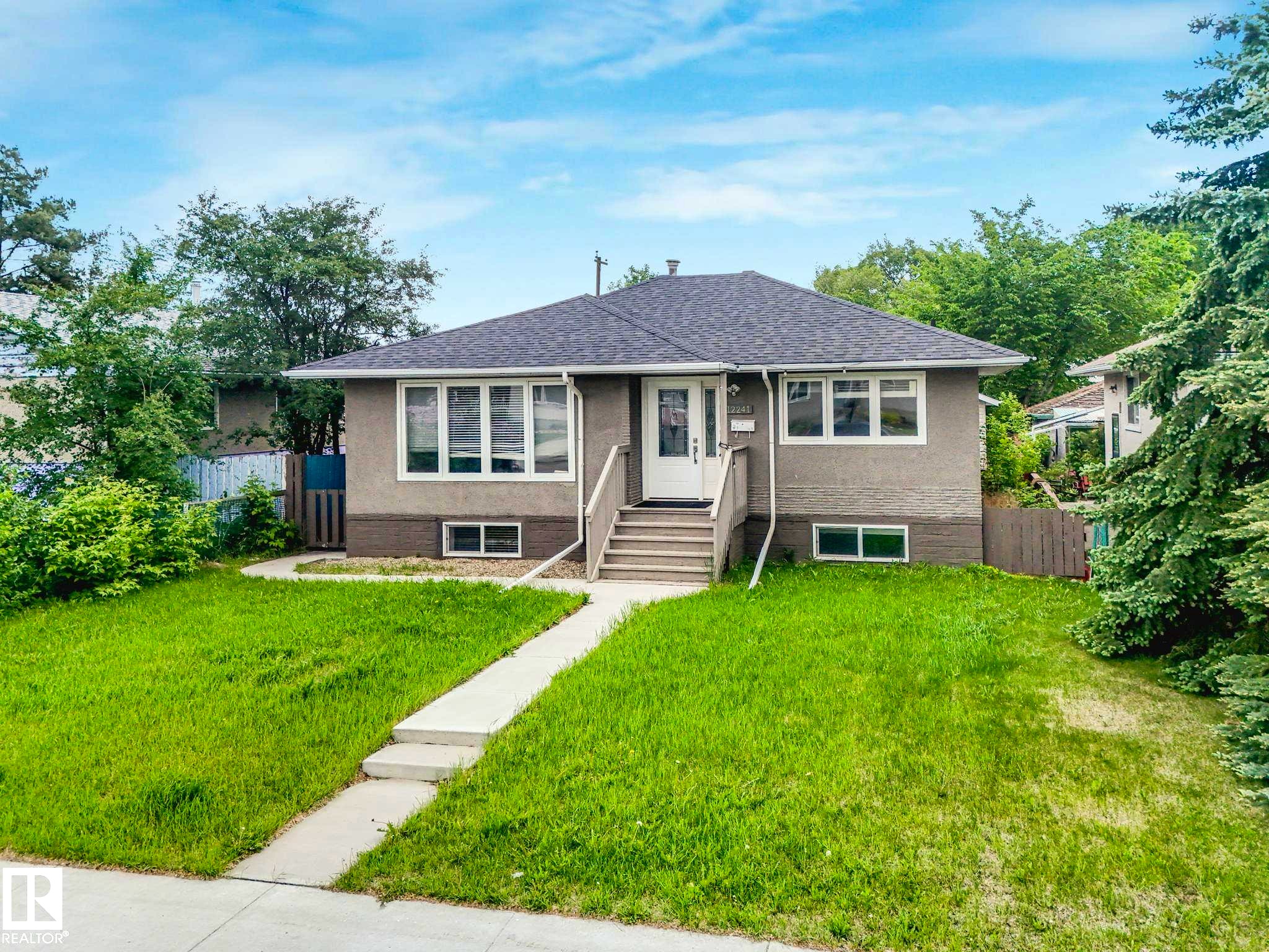 Single-story residence featuring a dark shingle roof and light-toned exterior siding - 12241 54 Street Nw, Edmonton, AB - Outdoor