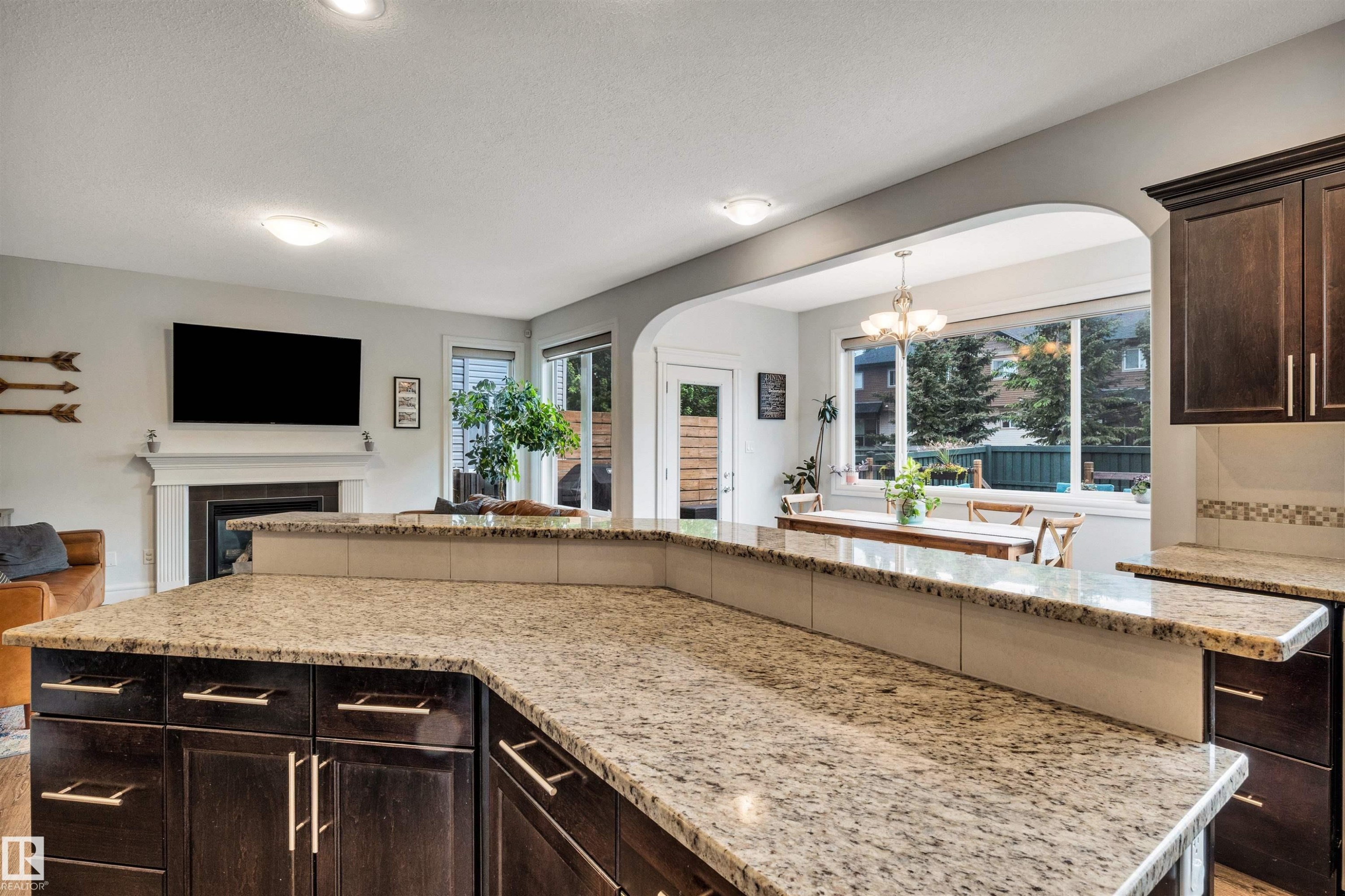 Kitchen island with light granite countertops and dark wood-finish cabinetry - 11935 21 Avenue, Edmonton, AB