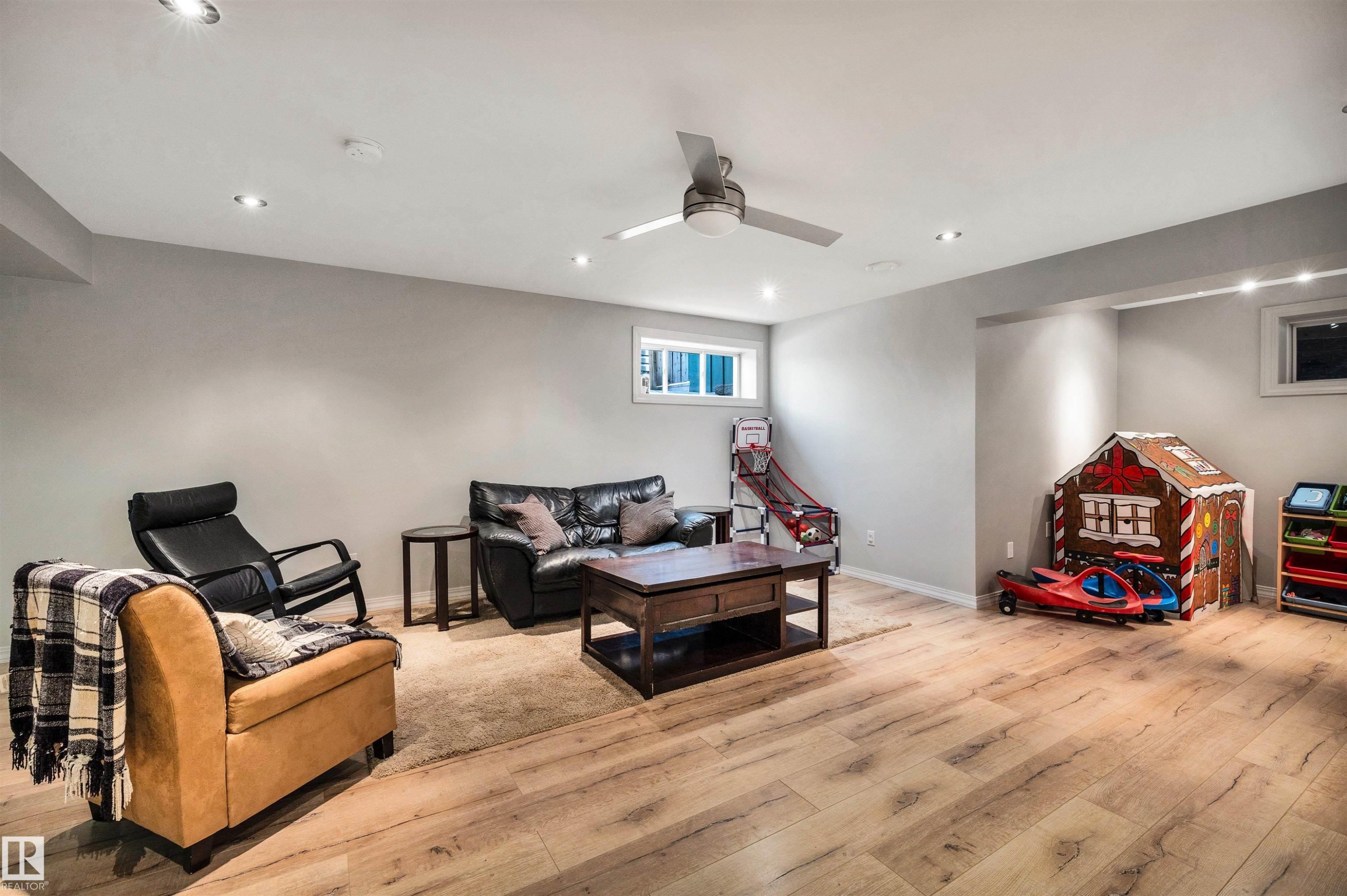 Spacious room featuring light wood-finish flooring, recessed lighting, and a ceiling fan - 11935 21 Avenue, Edmonton, AB