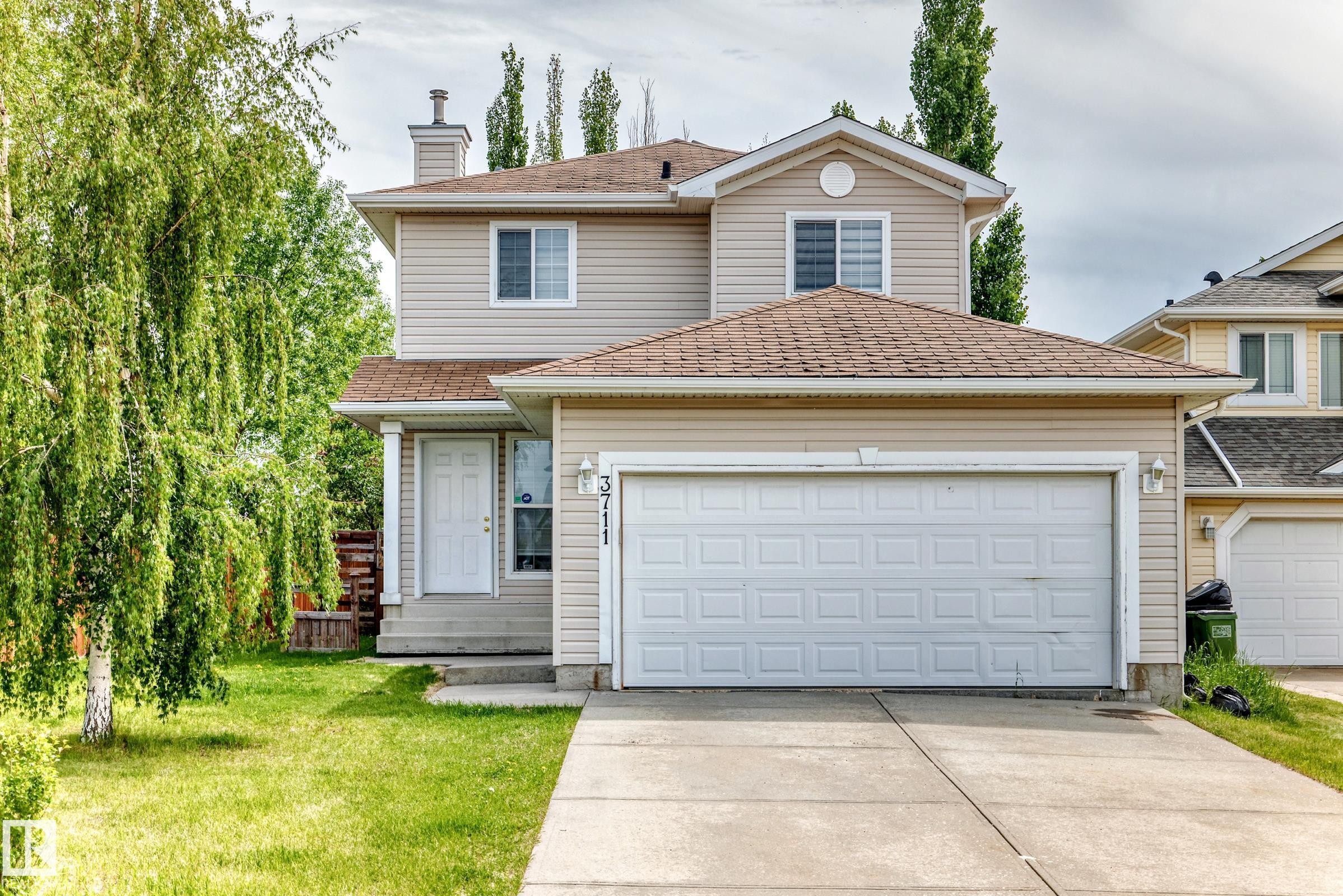 Two-story residence featuring light-toned siding and a brown shingled roof - 3711 22A St, Edmonton, AB