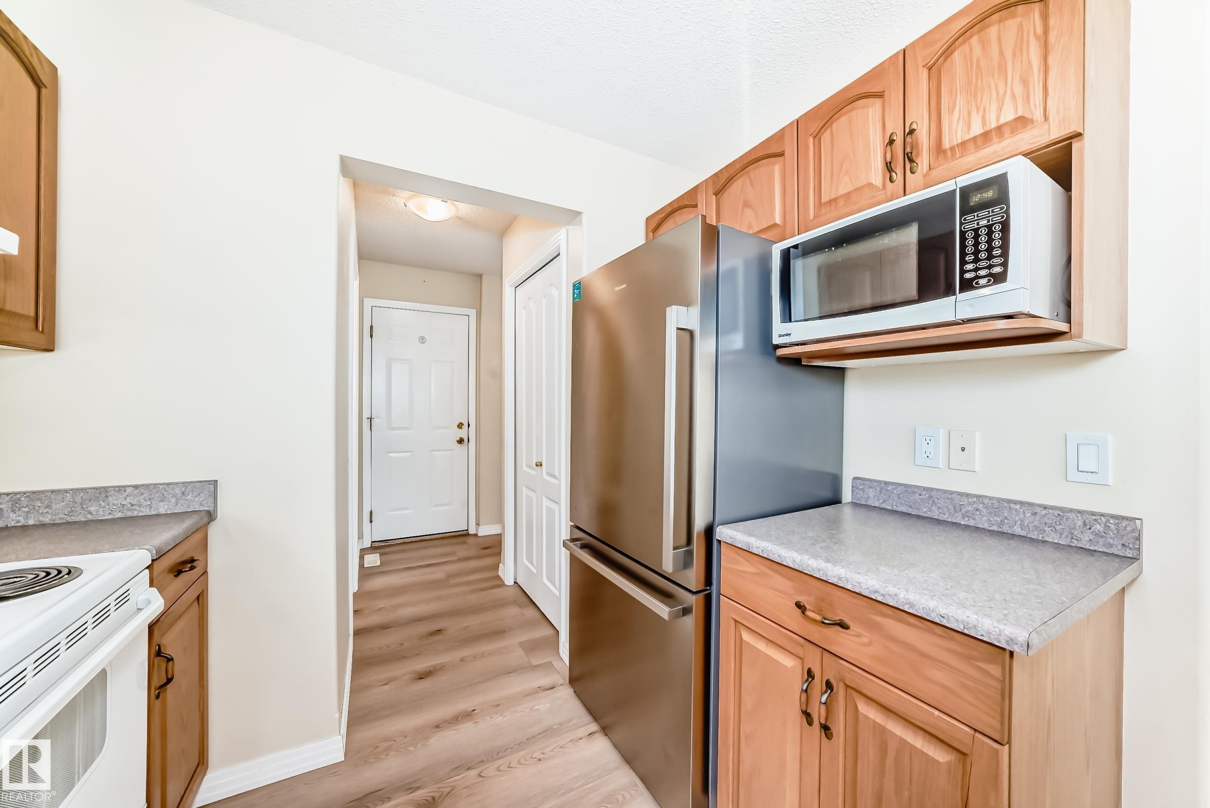 Kitchen area featuring light wood cabinetry and light-toned countertops - 3711 22A St, Edmonton, AB