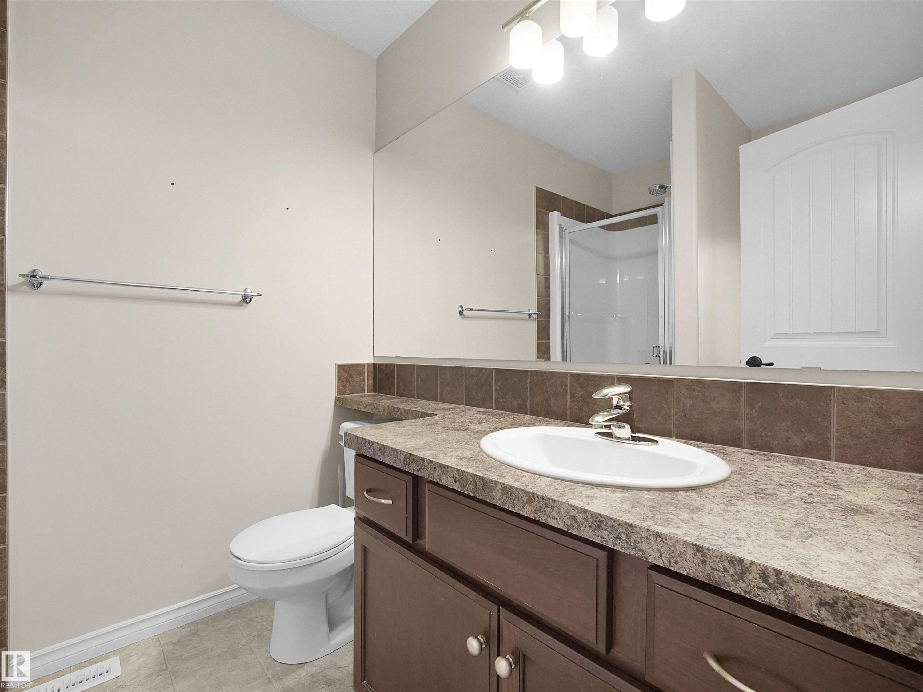 Bathroom featuring a vanity with a white oval sink, chrome faucet, and dark brown cabinetry - 21316 45A Avenue Nw, Edmonton, AB