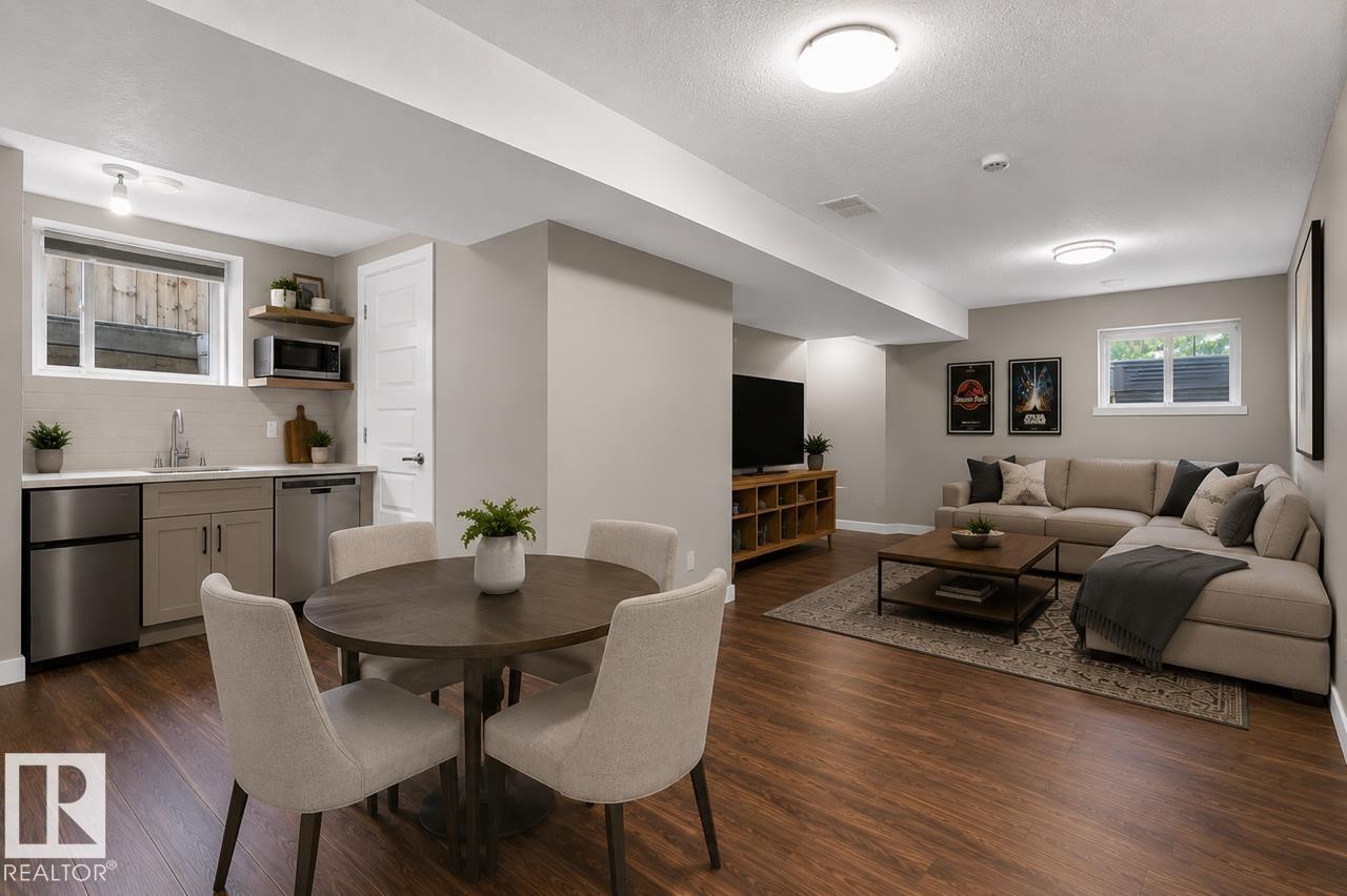 Open-concept living space with wood-finish flooring, recessed lighting, and a neutral wall palette - 8506 80 Avenue, Edmonton, AB