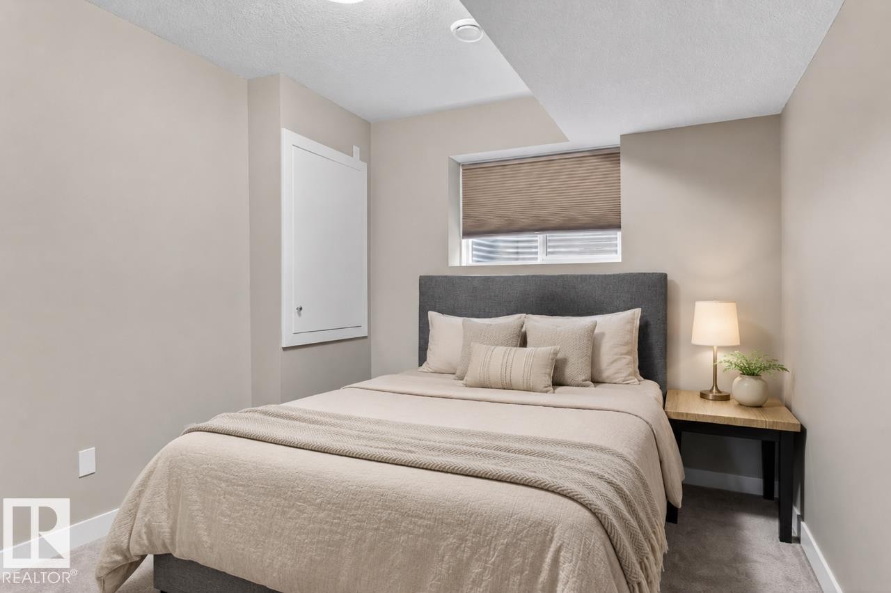 Carpeted bedroom with neutral wall tones and white baseboards - 8506 80 Avenue, Edmonton, AB