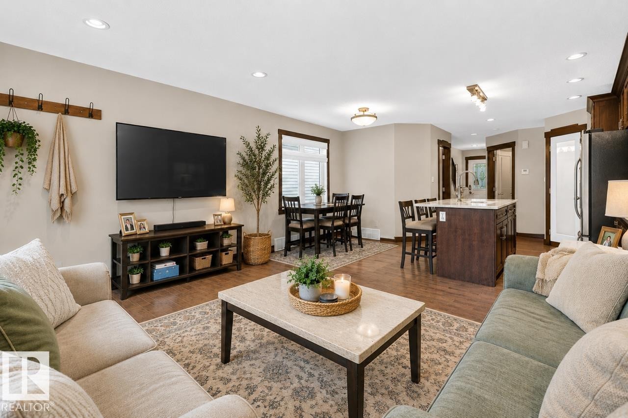 Open-concept living area featuring wood-finish flooring, recessed lighting, and neutral wall tones - 8506 80 Avenue, Edmonton, AB