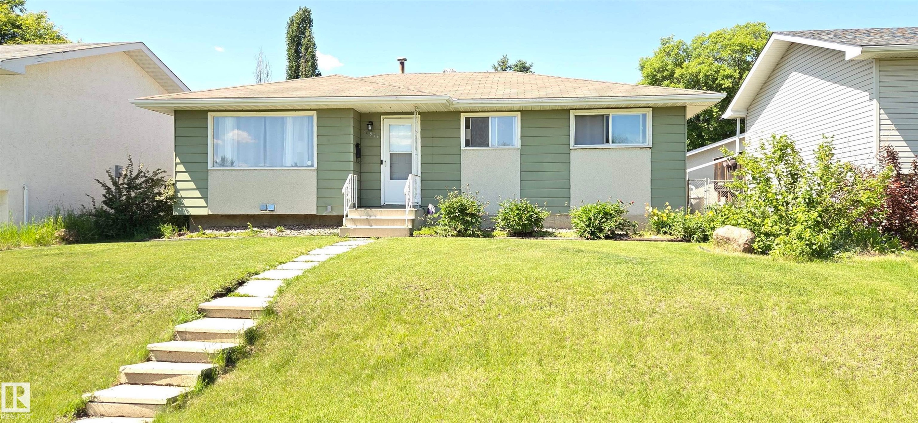 Ranch-style exterior with green siding and cream accents - 10924 30 Street, Edmonton, AB