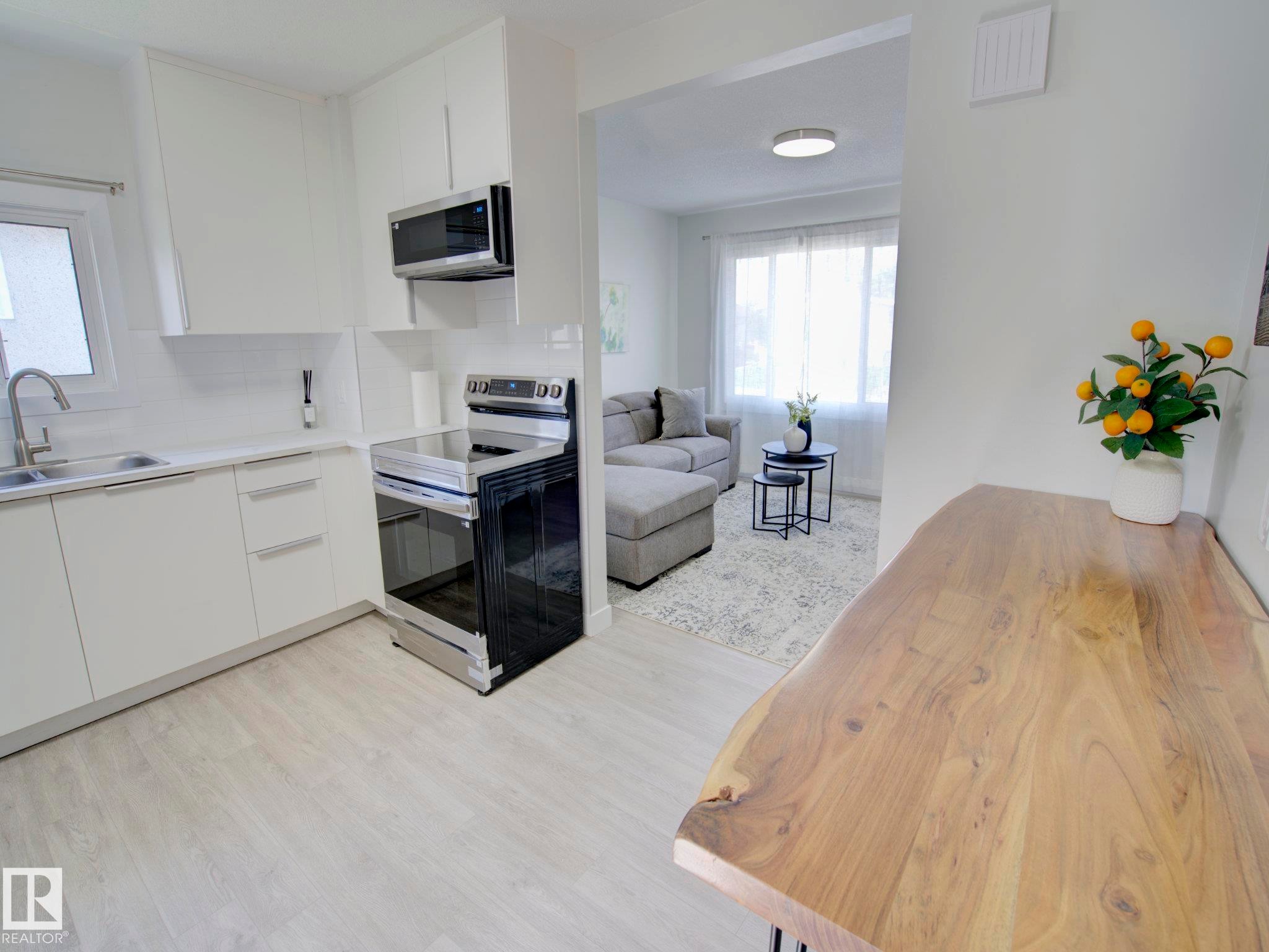 Modern kitchen with white cabinetry and stainless steel appliances - 9909 157 Street, Edmonton, AB