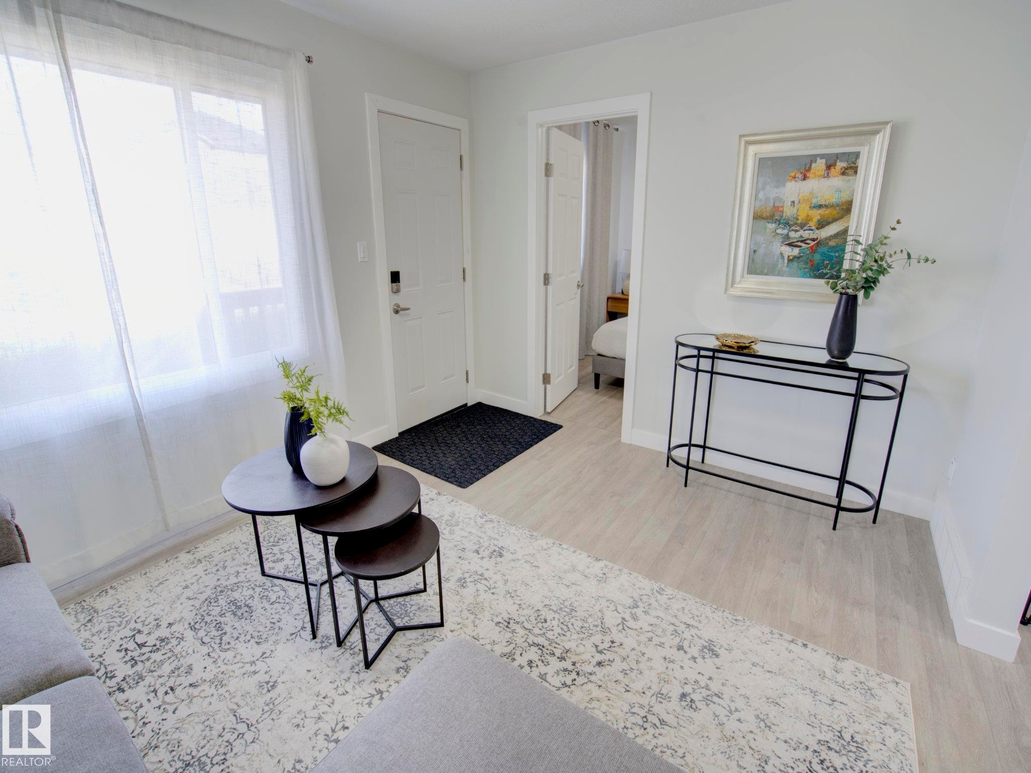 Entryway featuring light wood-finish flooring and a white paneled door - 9909 157 Street, Edmonton, AB