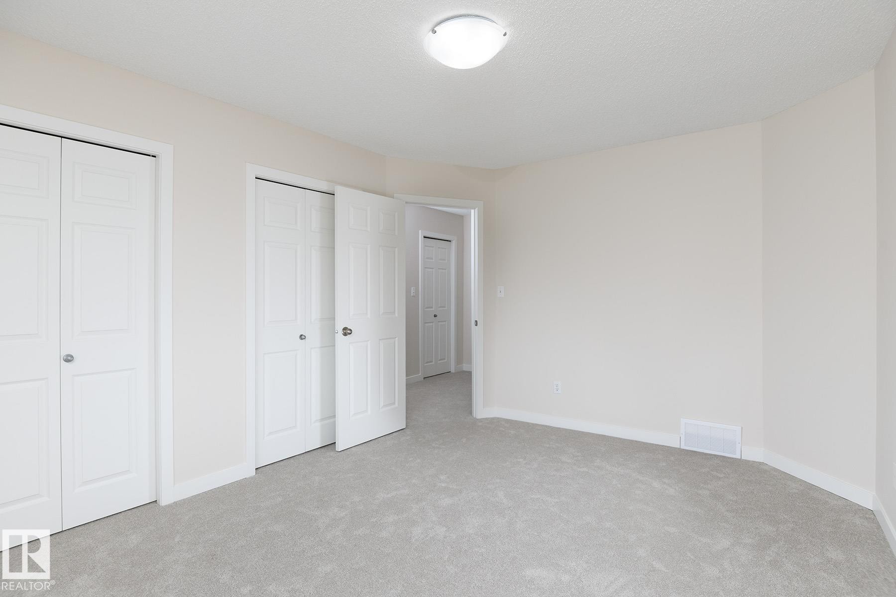 Interior room featuring light-colored carpeting and off-white walls - #55 14603 Miller Bv Nw, Edmonton, AB