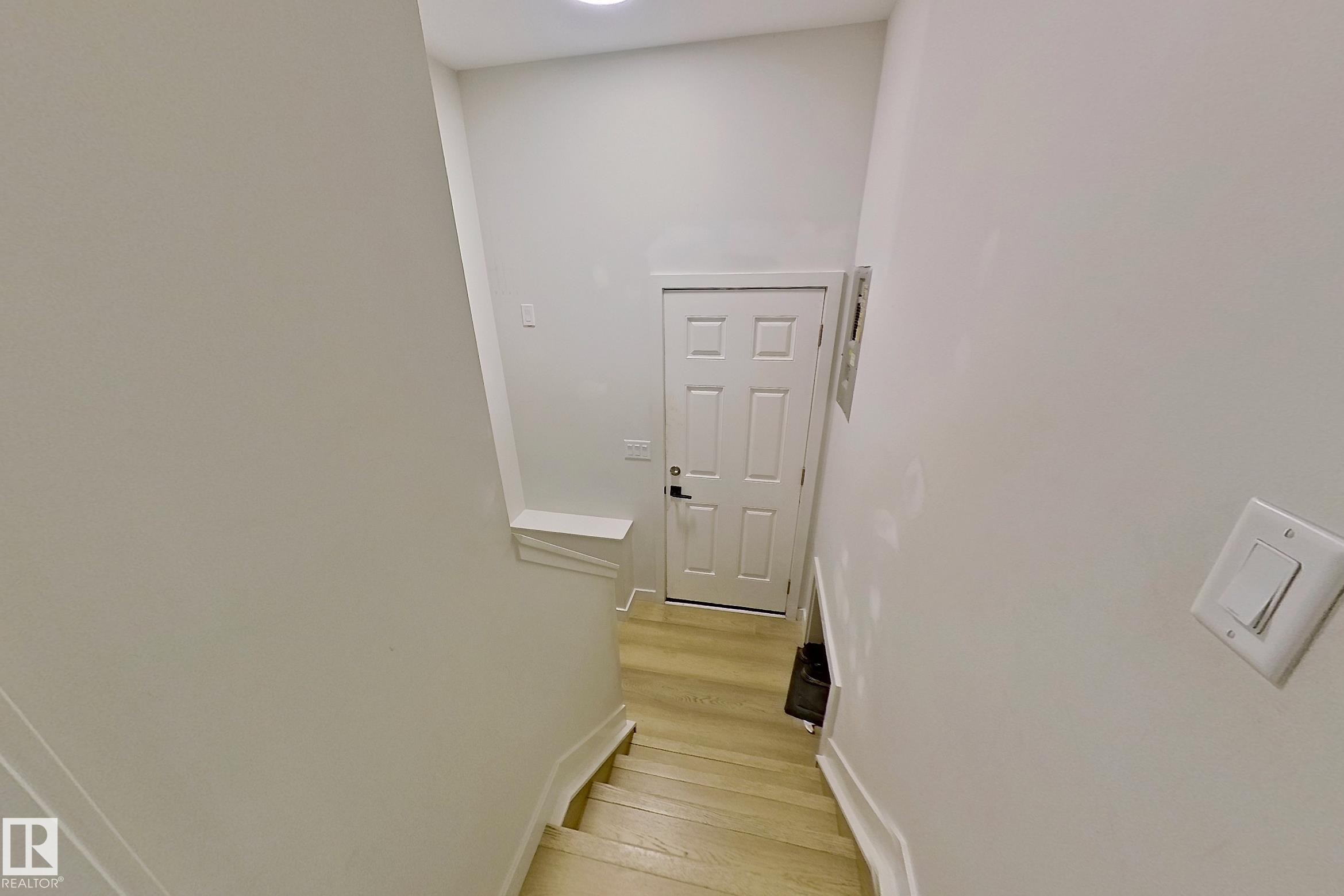 Staircase with light wood-finish treads and white risers - 3054 28 Avenue, Edmonton, AB