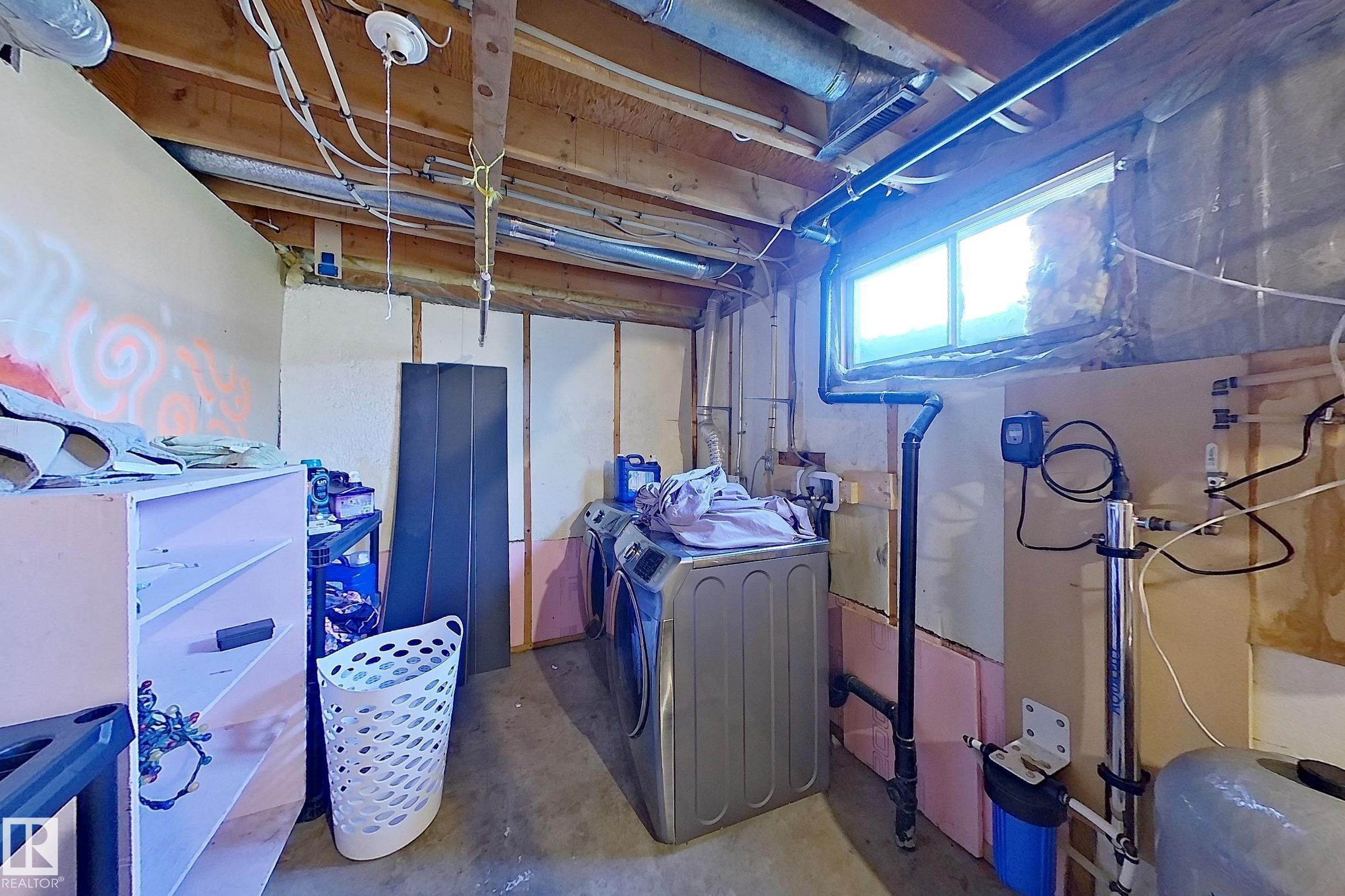 Unfinished basement area featuring a utility window, exposed ceiling joists, and concrete flooring - 3054 28 Avenue, Edmonton, AB