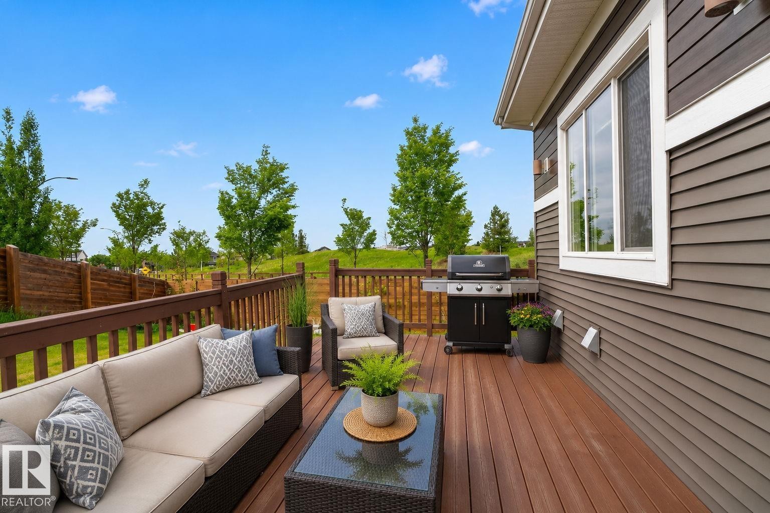 Expansive rear deck featuring wood-finish flooring and a wood railing - 704 39 Street, Edmonton, AB
