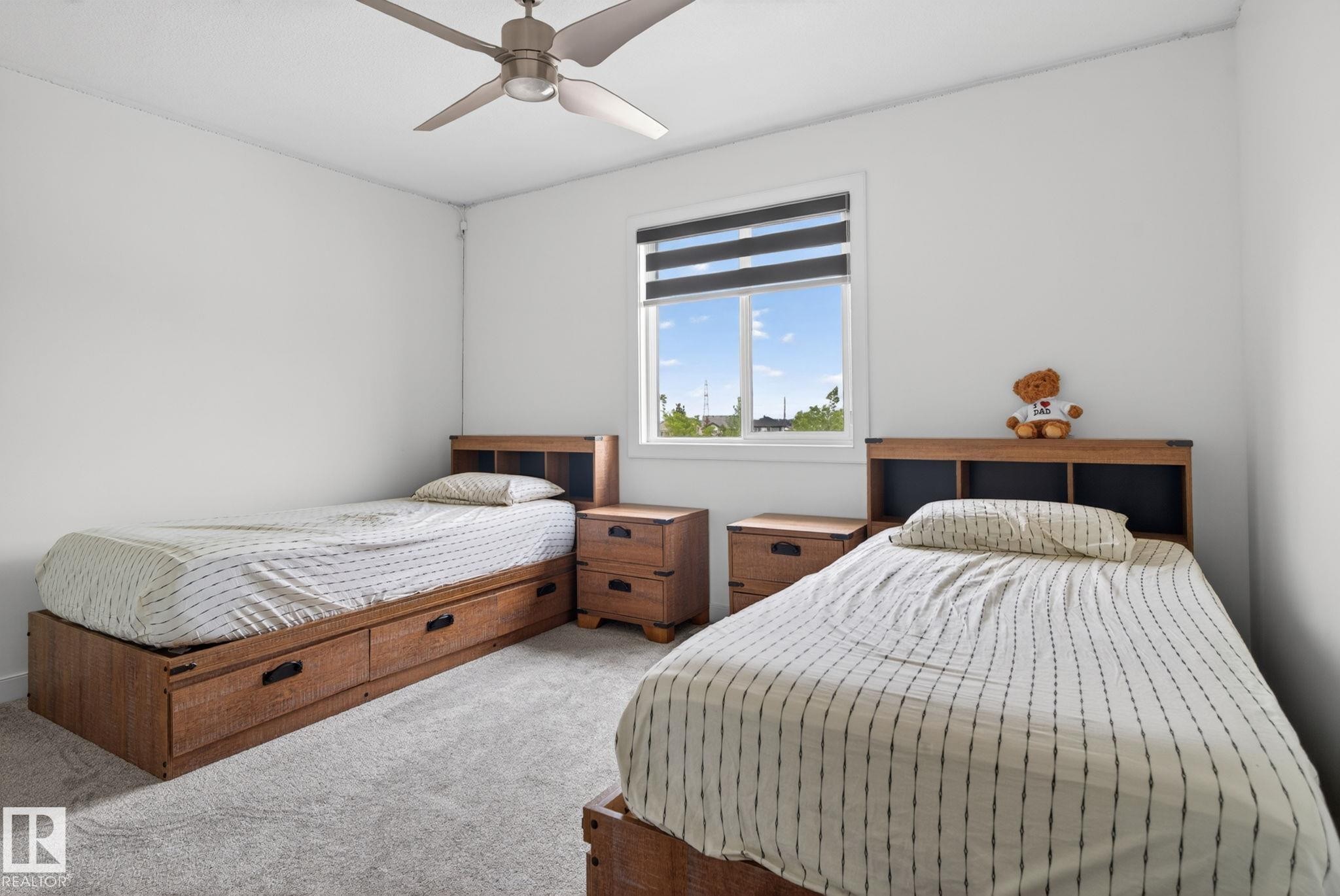 Bright room featuring a window with integrated blinds, a ceiling fan, and light-colored carpet flooring - 704 39 Street, Edmonton, AB