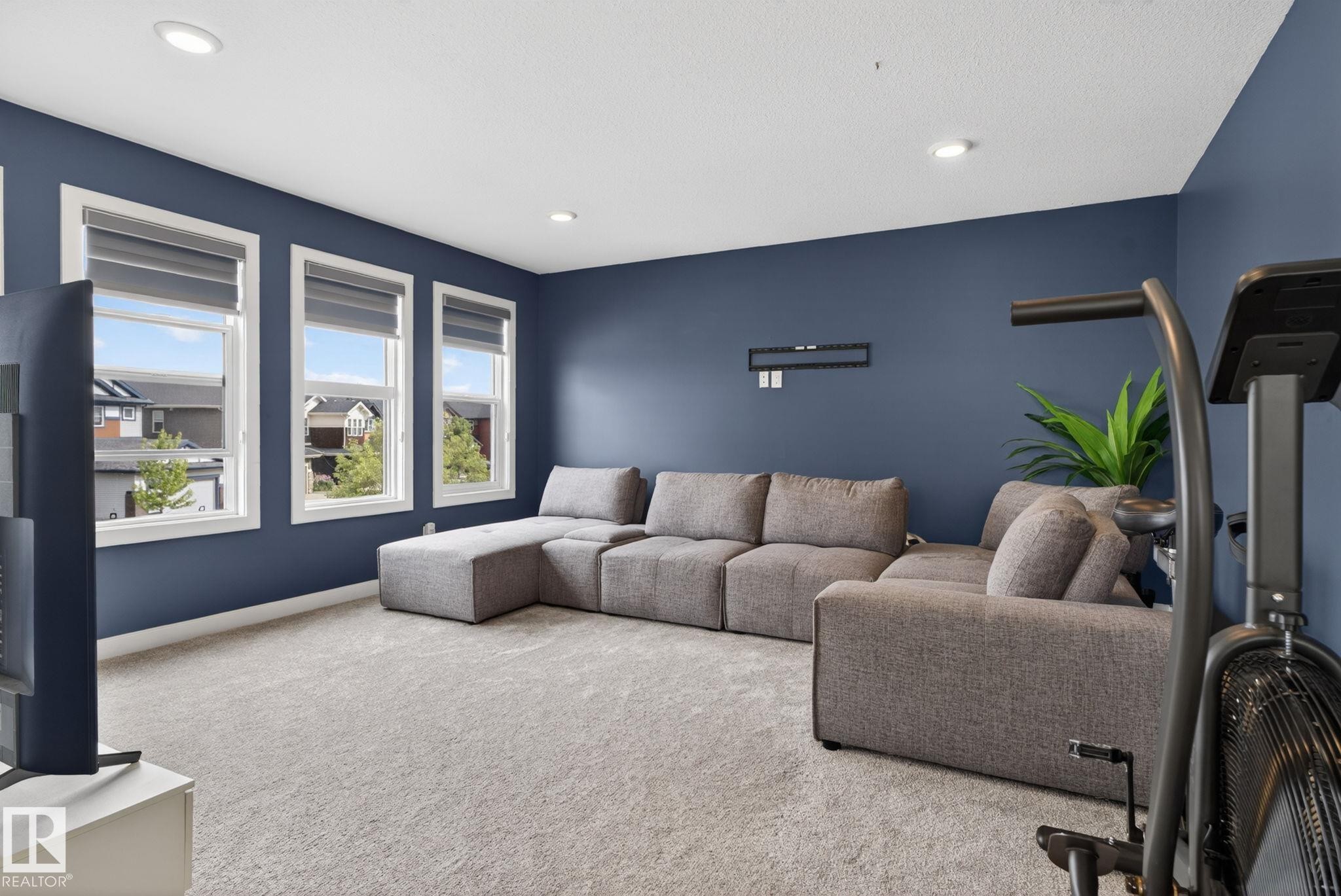 Spacious room with plush carpeting, recessed lighting, and three large windows with window treatments - 704 39 Street, Edmonton, AB