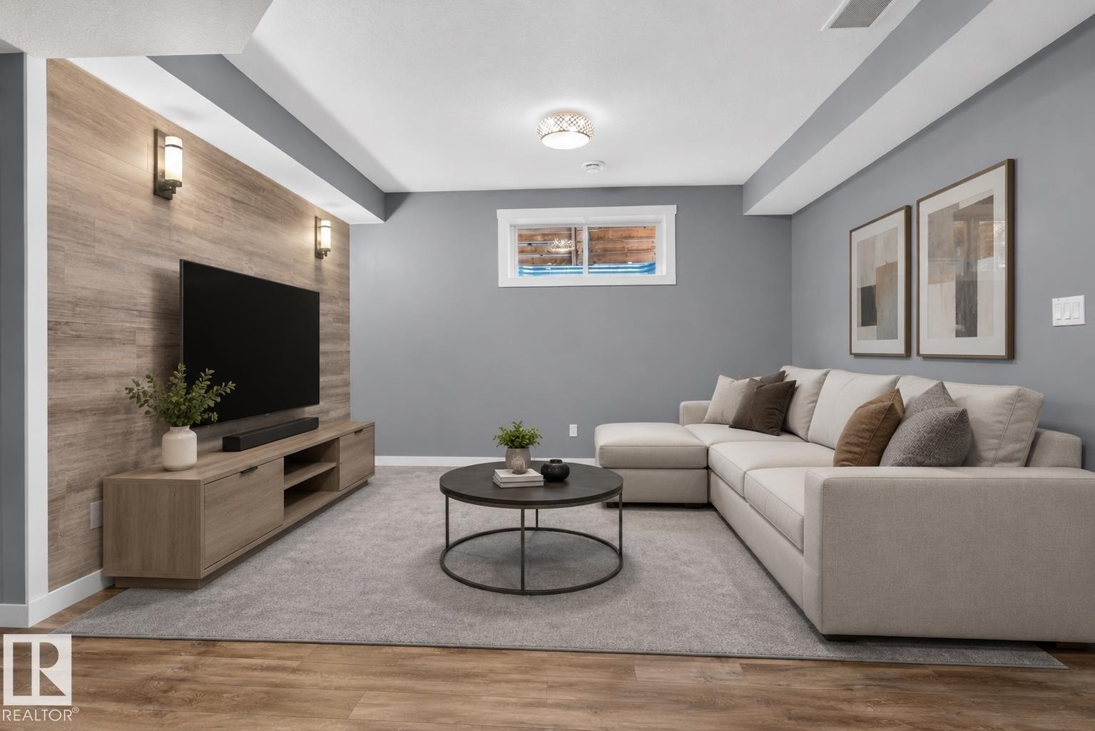 Entertainment area featuring a wood-finish accent wall, sconce lighting, recessed ceiling, and a single window with white trim - 704 39 Street, Edmonton, AB