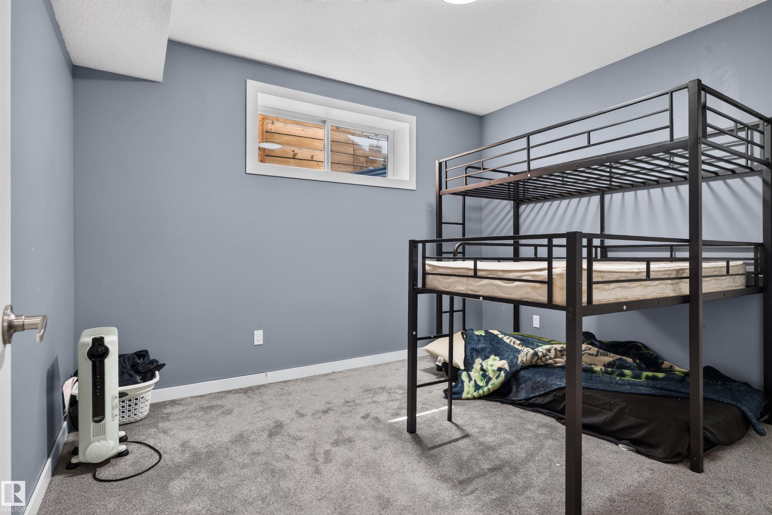 Light gray wall paint with white trim, gray carpet flooring, and a white-framed egress window - 704 39 Street, Edmonton, AB