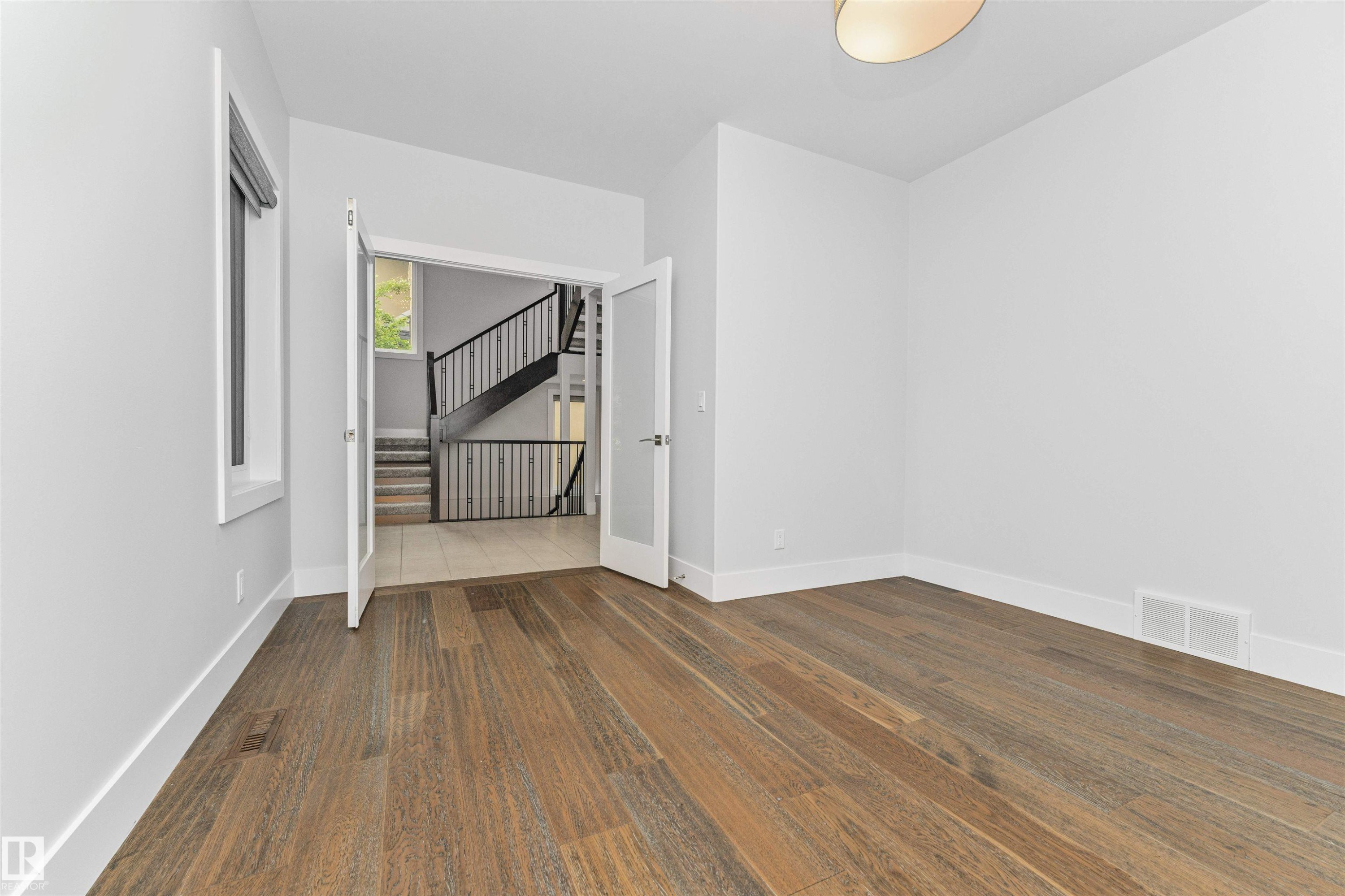 Room with wide plank wood-finish flooring and white baseboards - 3310 Watson Bay, Edmonton, AB