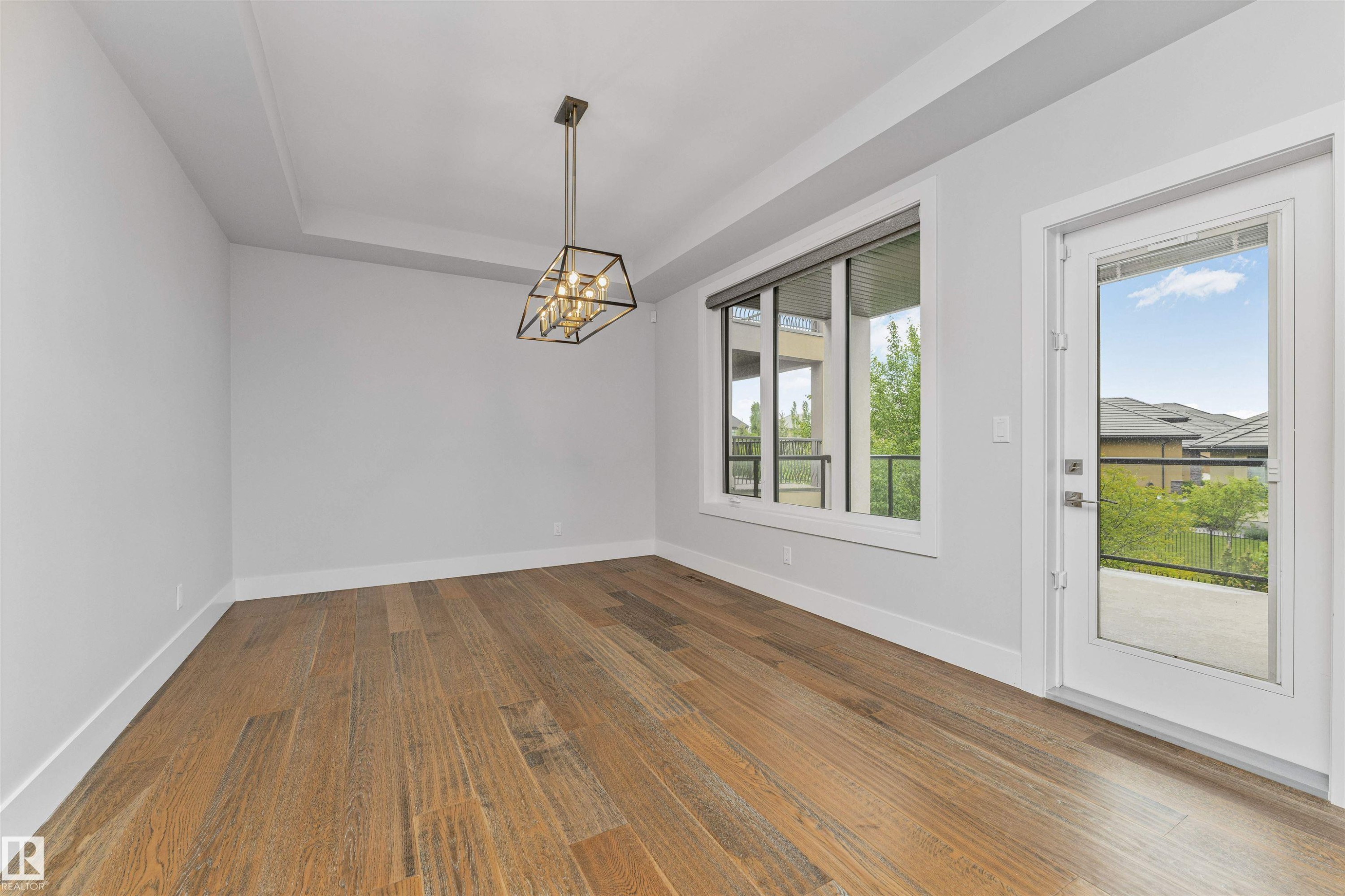 Hardwood-style flooring throughout, complemented by crisp white baseboards and walls - 3310 Watson Bay, Edmonton, AB