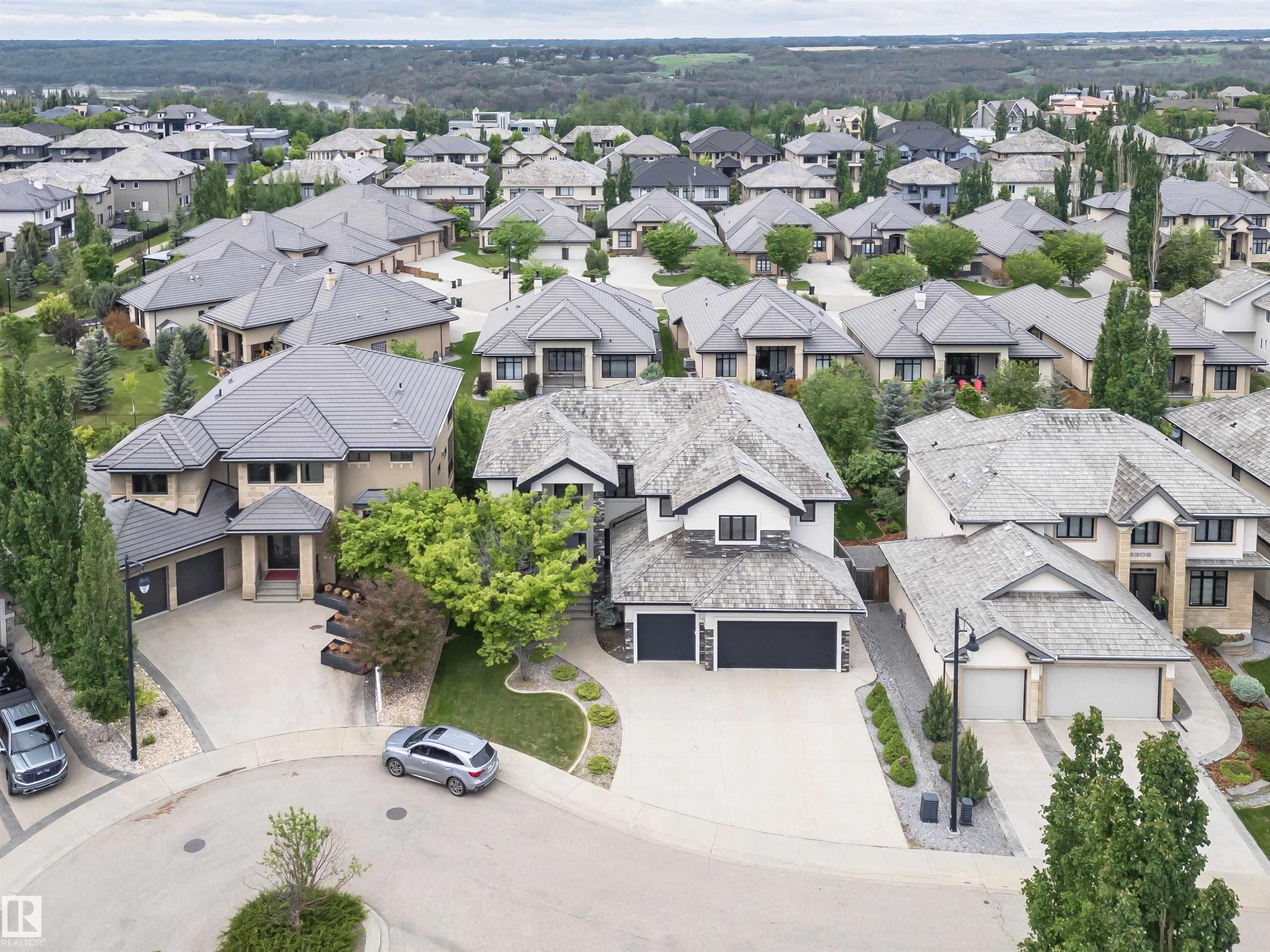 Spacious home featuring a multi-car garage, extensive concrete driveway, and mature landscaping - 3310 Watson Bay, Edmonton, AB