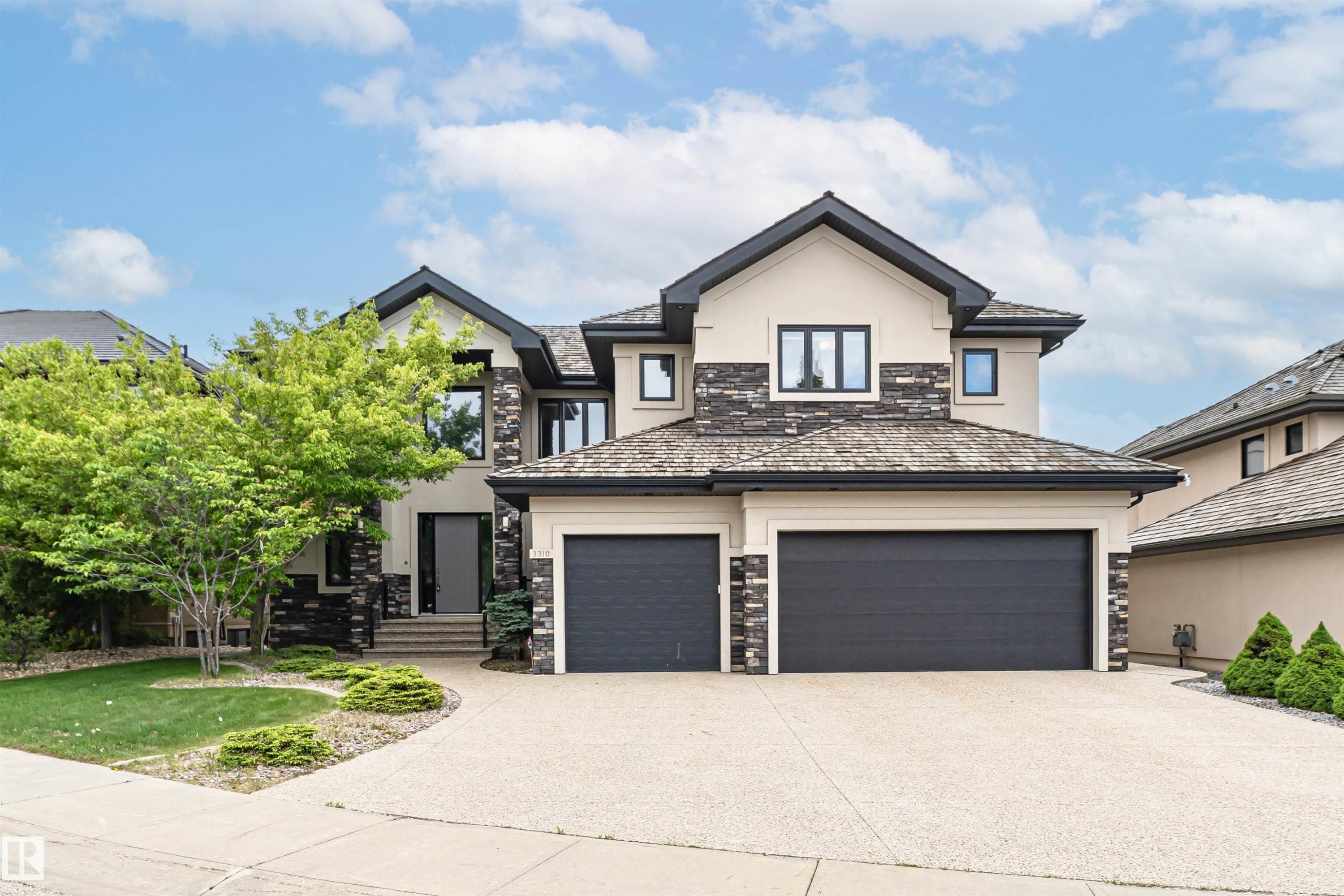 Contemporary two-story residence featuring a multi-textured exterior of stucco and stone accents - 3310 Watson Bay, Edmonton, AB