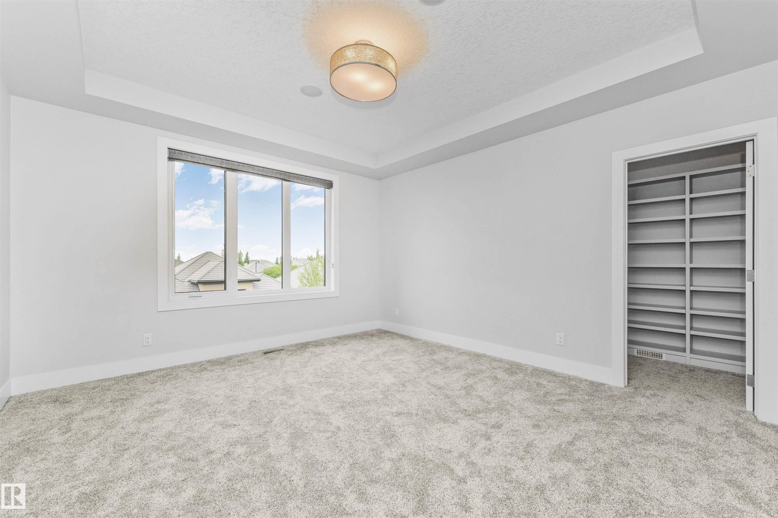 Spacious room featuring plush grey carpeting and a large window with white trim - 3310 Watson Bay, Edmonton, AB