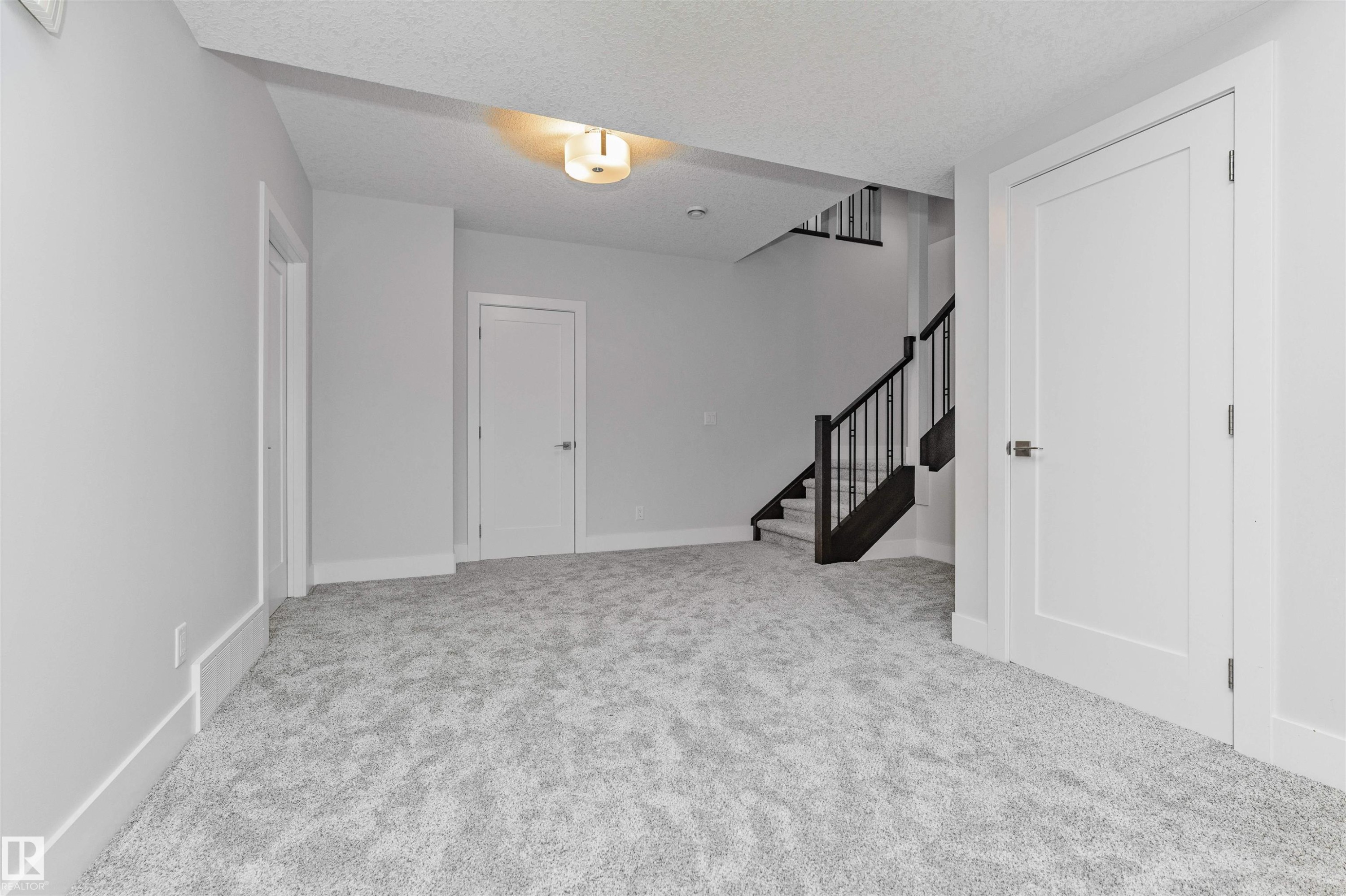 Spacious room featuring light gray carpeting, crisp white walls, and bright white trim - 3310 Watson Bay, Edmonton, AB