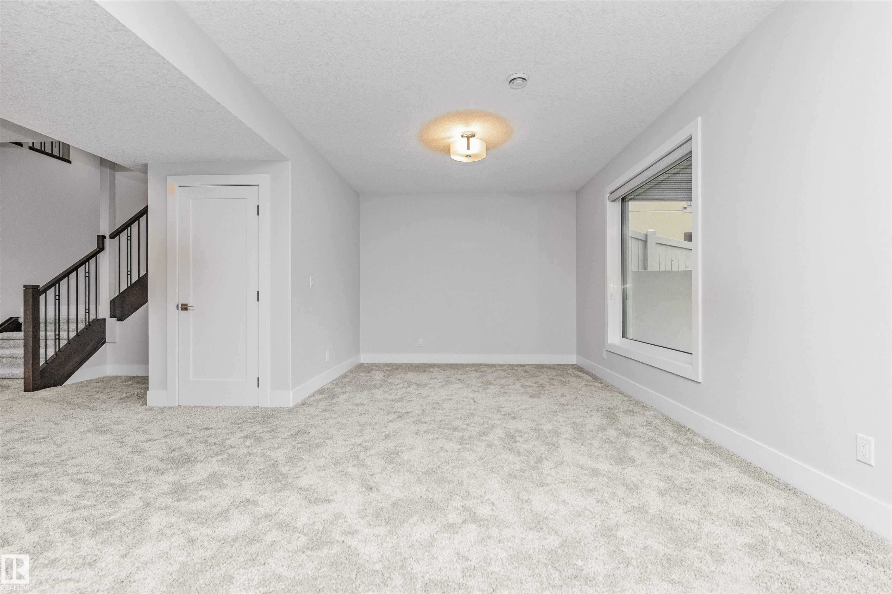 Spacious room featuring light-toned carpet flooring, neutral painted walls, and white baseboards - 3310 Watson Bay, Edmonton, AB