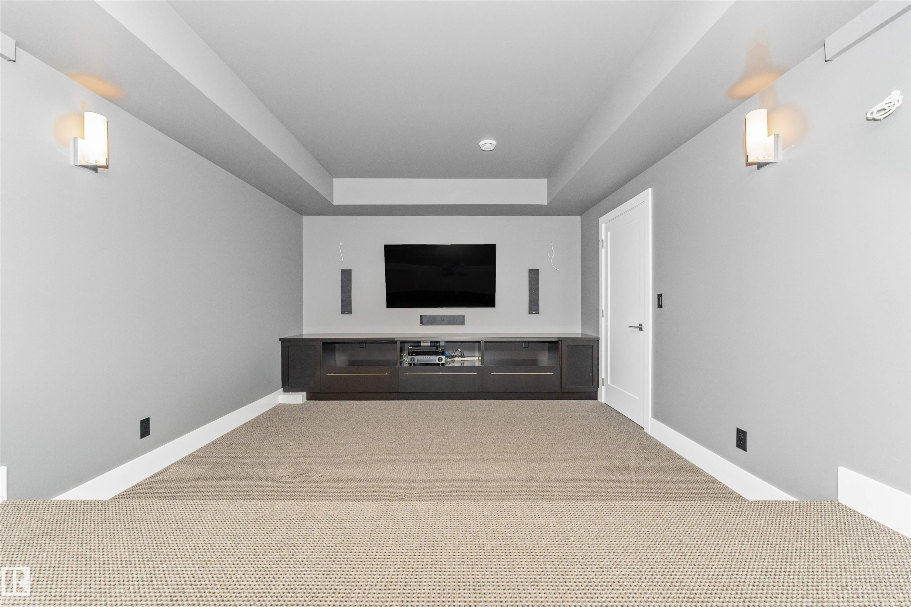 Dedicated media room featuring a large mounted display, integrated sound system, and a built-in media console with storage - 3310 Watson Bay, Edmonton, AB