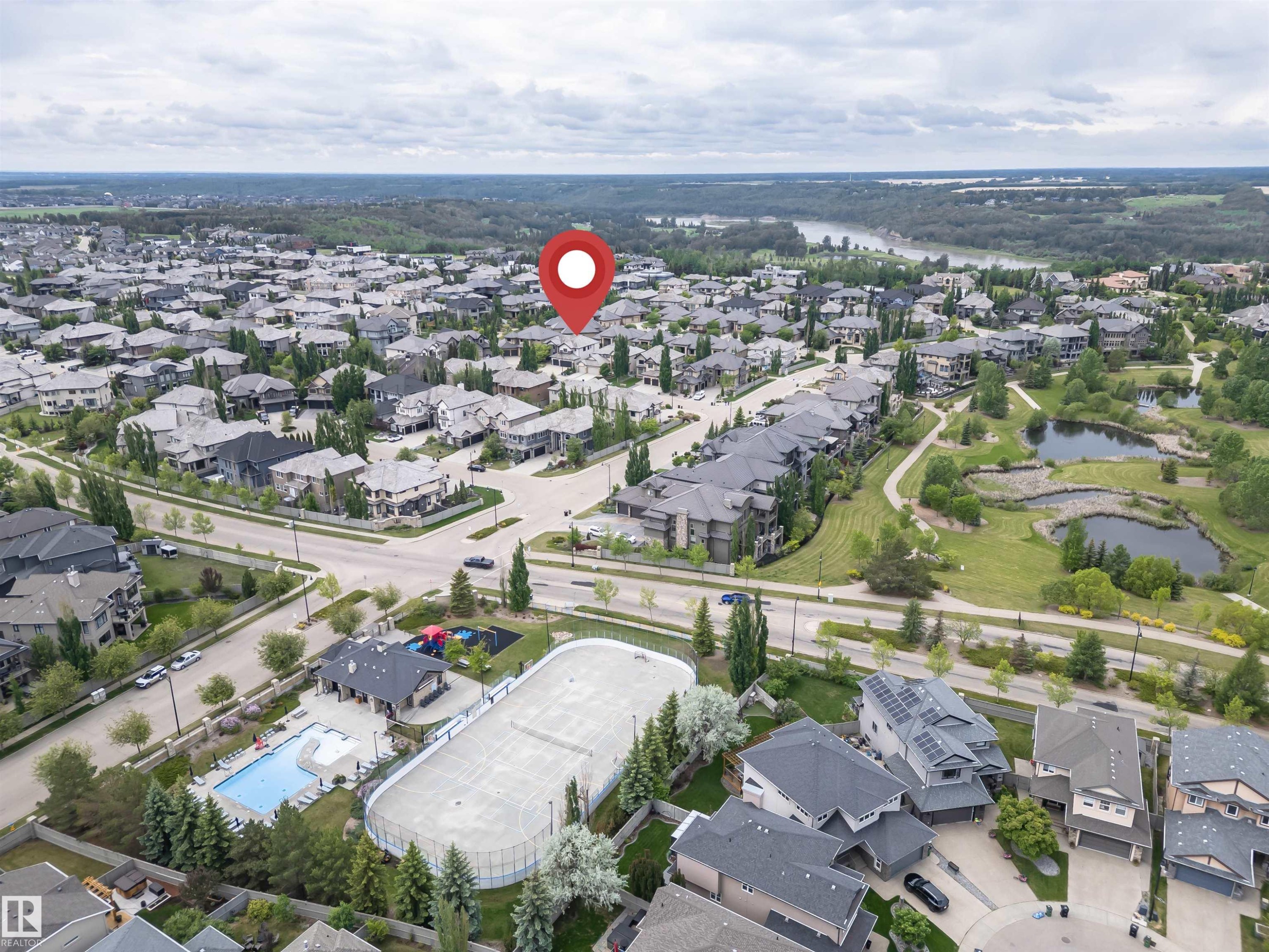 Suburban neighborhood featuring varied residential architecture, established streetscapes, and a prominent green space with water features - 3310 Watson Bay, Edmonton, AB