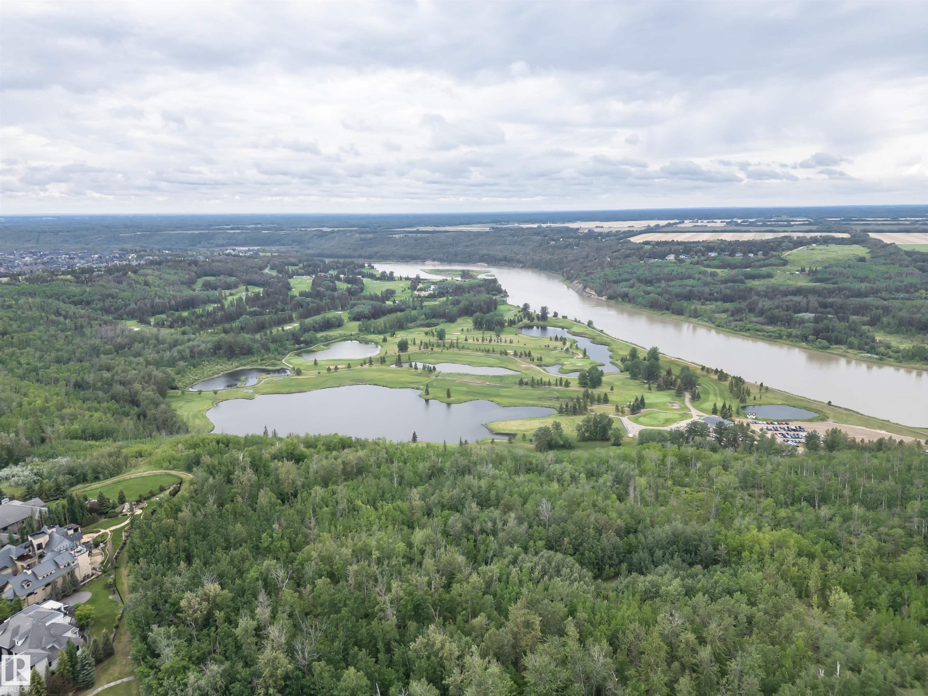 Expansive aerial panorama showcasing a meandering river, a golf course with multiple water features, and dense mature forest - 3310 Watson Bay, Edmonton, AB