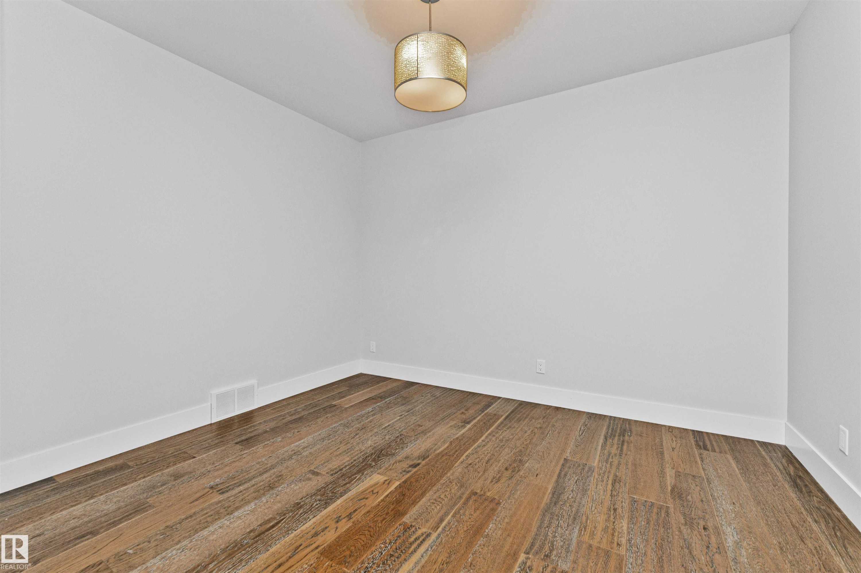 Room featuring wood-finish plank flooring, crisp white baseboards, and neutral wall paint - 3310 Watson Bay, Edmonton, AB