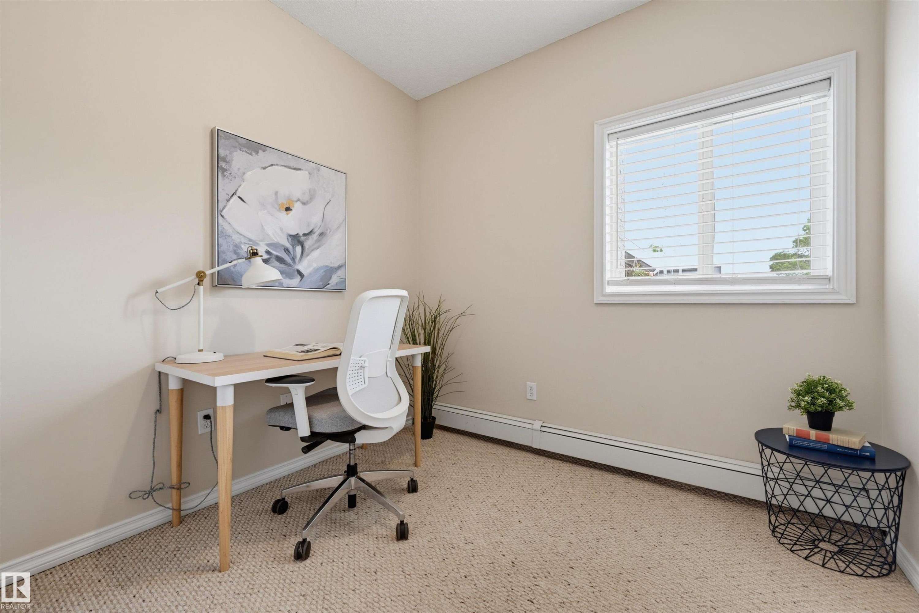 Carpeted room with a single window featuring white blinds, neutral wall paint, and white trim molding - 203 10719 80 Avenue, Edmonton, AB