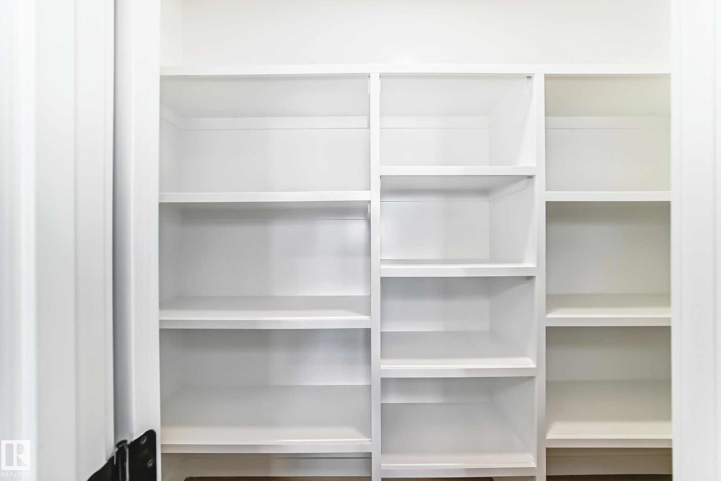Built-in white shelving unit with multiple compartments - 341 Roberts Wynd, Leduc, AB