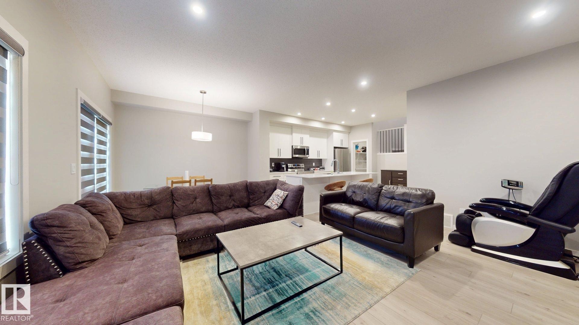 Open-concept living area featuring light wood-finish flooring, recessed lighting, and neutral wall tones - 607 31 Avenue, Edmonton, AB