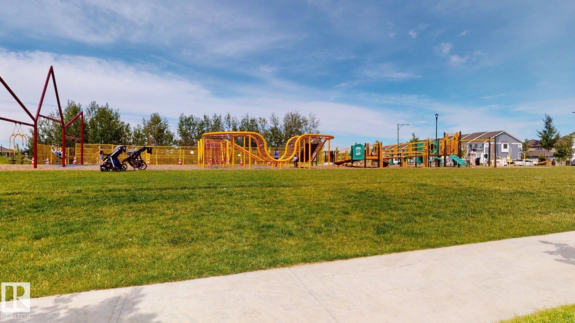 Expansive green space featuring a large playground with multiple activity structures, swings, and slides - 607 31 Avenue, Edmonton, AB