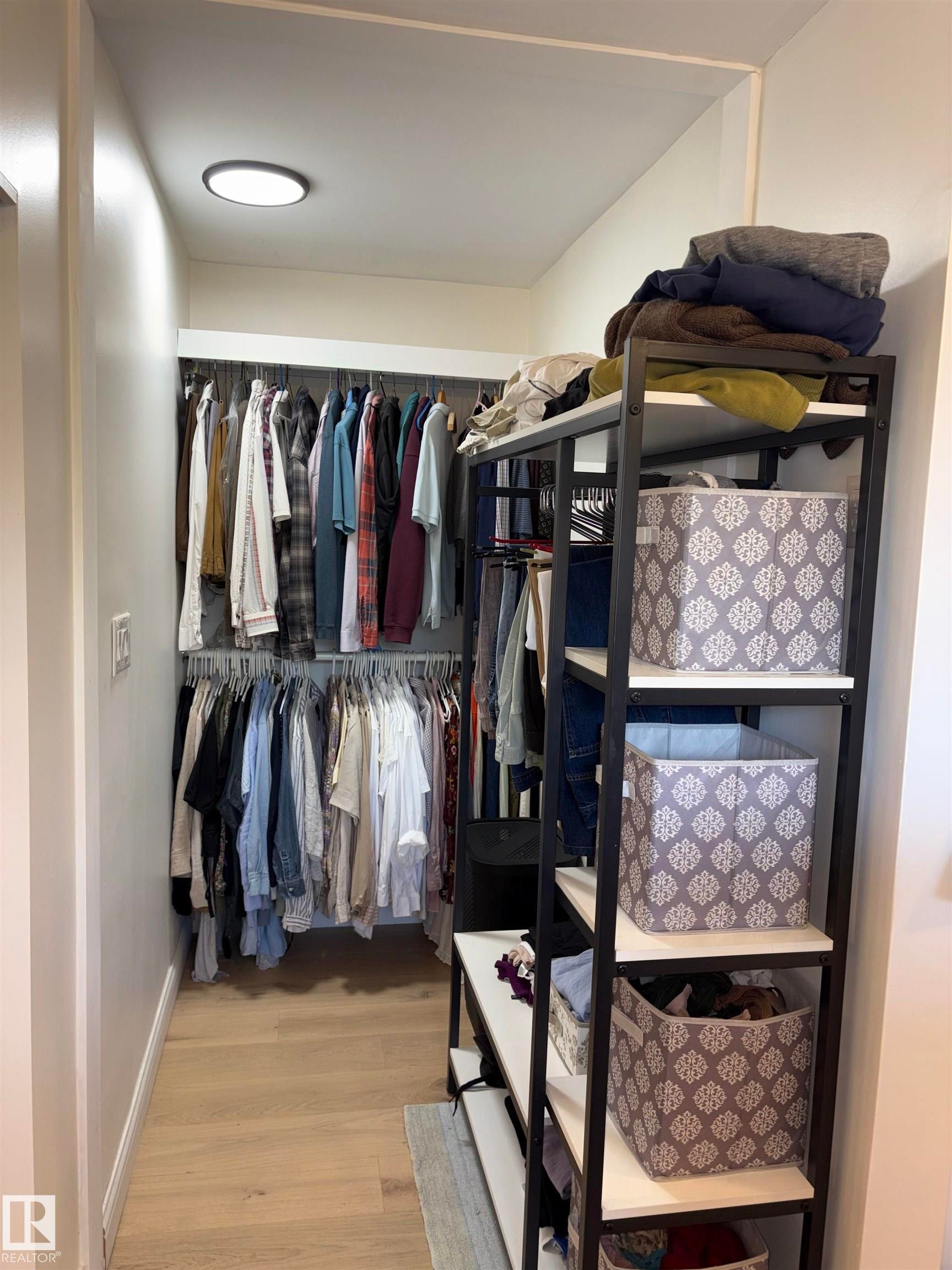 Walk-in closet featuring light wood-finish flooring, recessed lighting, and white walls - 14016 85 Avenue Nw, Edmonton, AB - Indoor With Storage