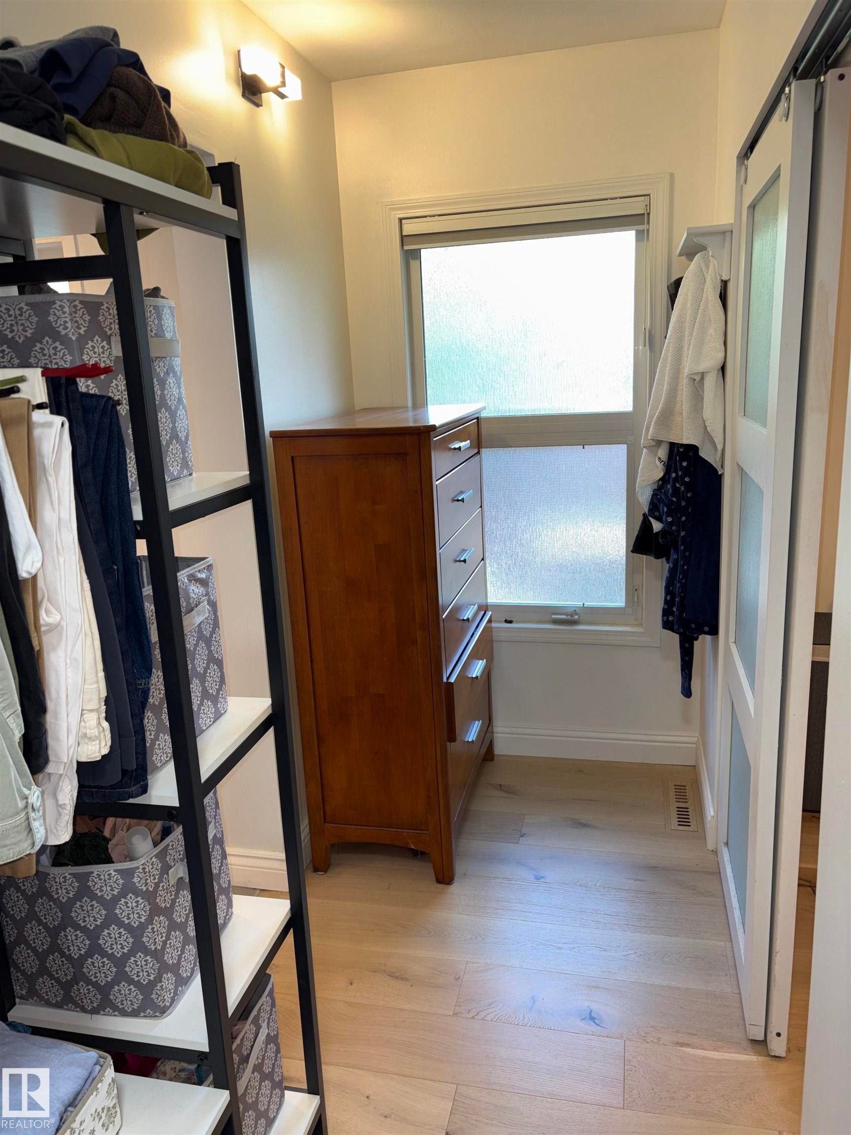 Bright interior space featuring light wood-finish flooring, a window with frosted glass, and white baseboards - 14016 85 Avenue Nw, Edmonton, AB - Indoor