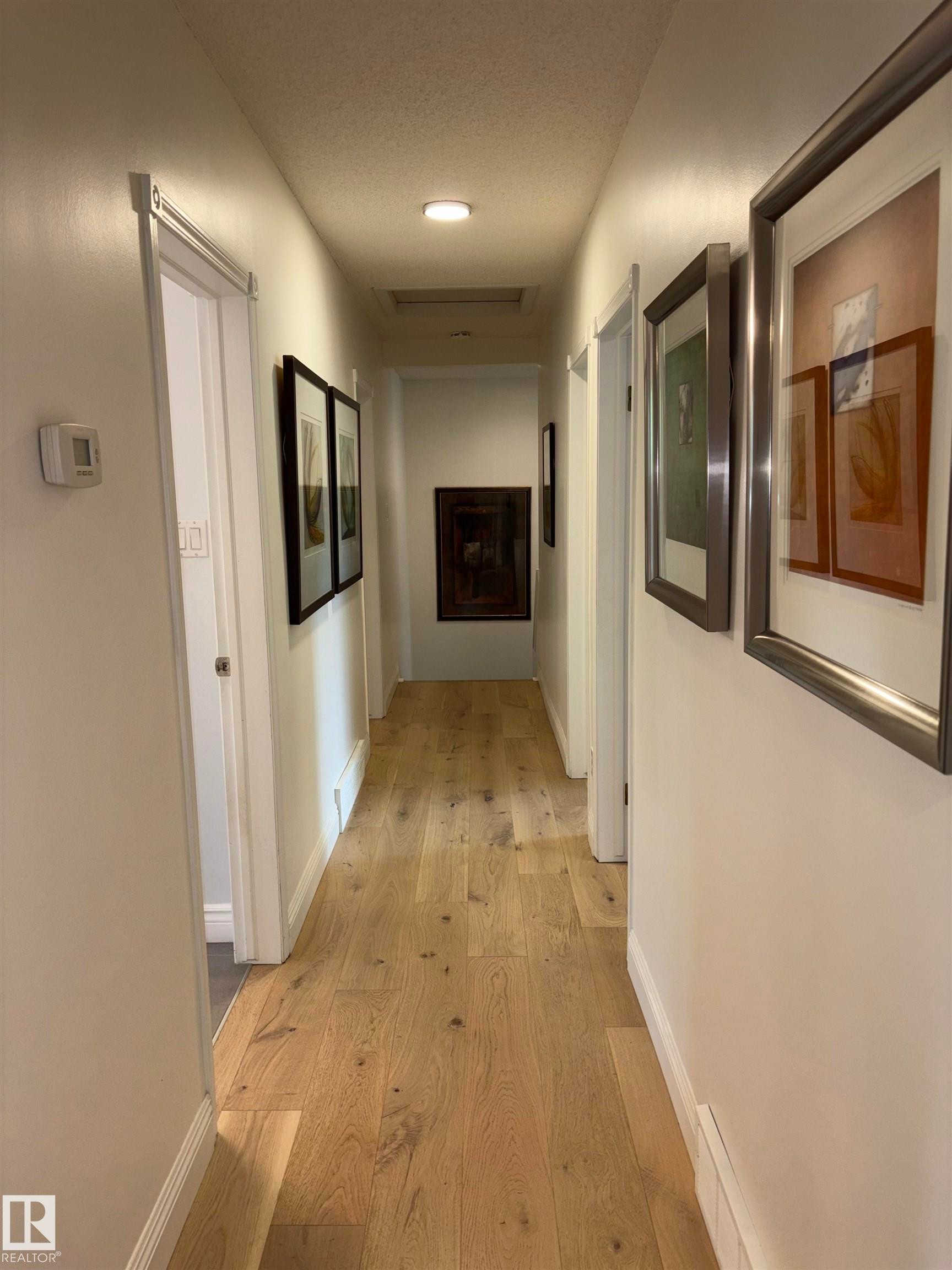 Hallway featuring light wood-finish flooring, recessed ceiling lighting, and white baseboards - 14016 85 Avenue Nw, Edmonton, AB - Indoor Photo Showing Other Room