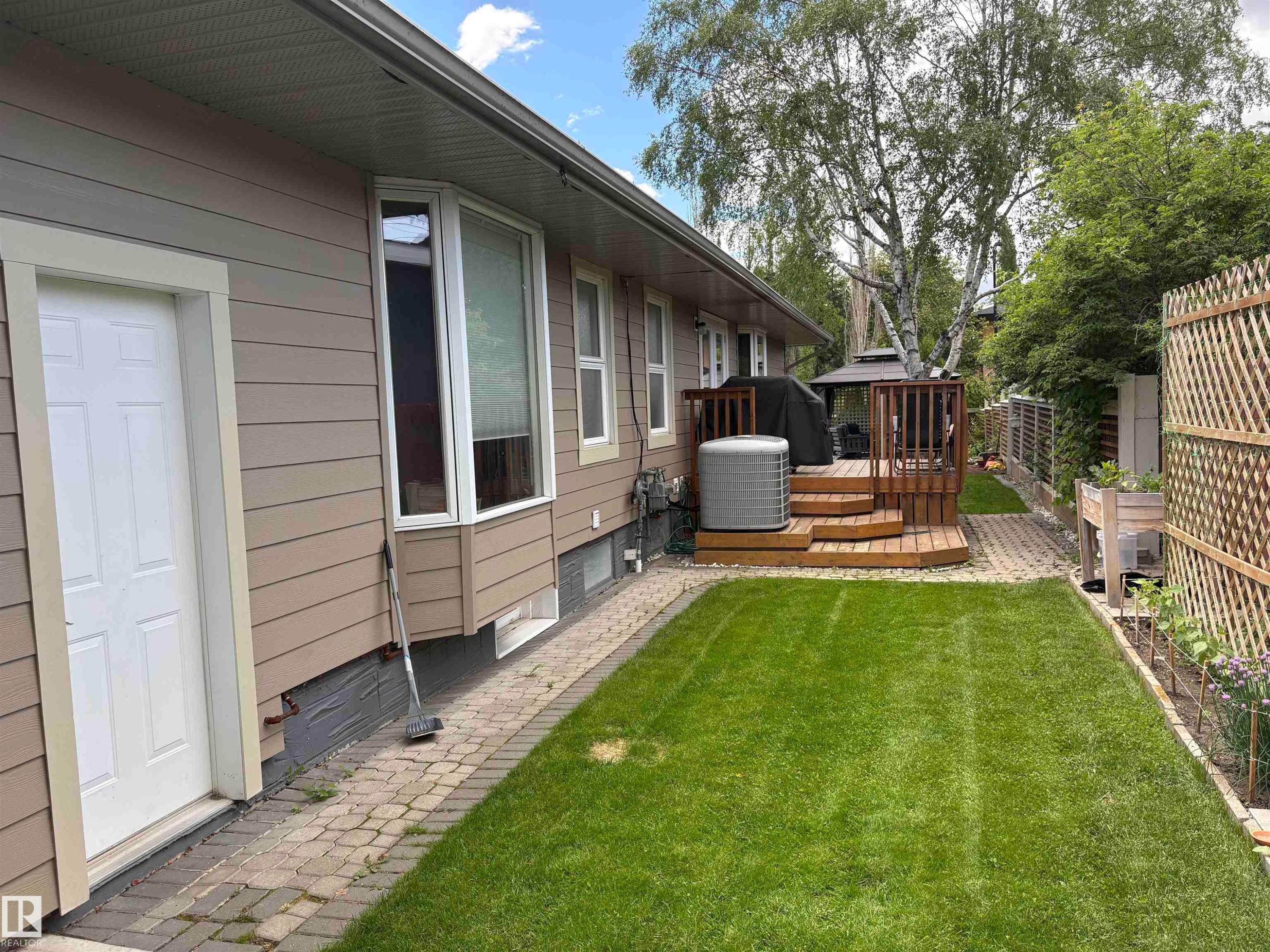 Expansive backyard featuring a manicured lawn, a multi-level wooden deck with privacy railings, and an integrated gazebo - 14016 85 Avenue Nw, Edmonton, AB - Outdoor With Deck Patio Veranda With Exterior