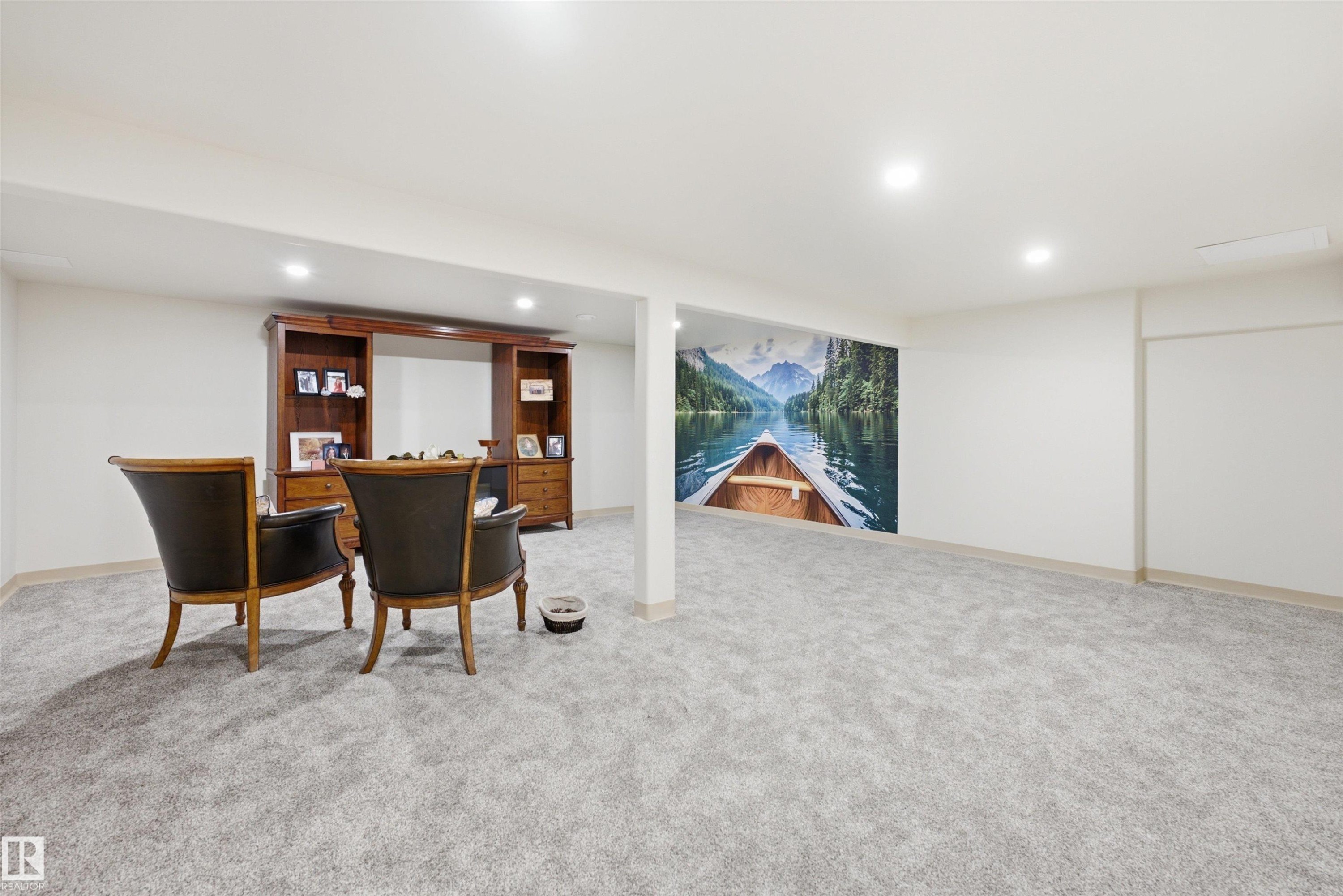 Spacious lower-level room featuring light gray carpet flooring and recessed lighting - A38 Bernice Ave, Rural Leduc County, AB
