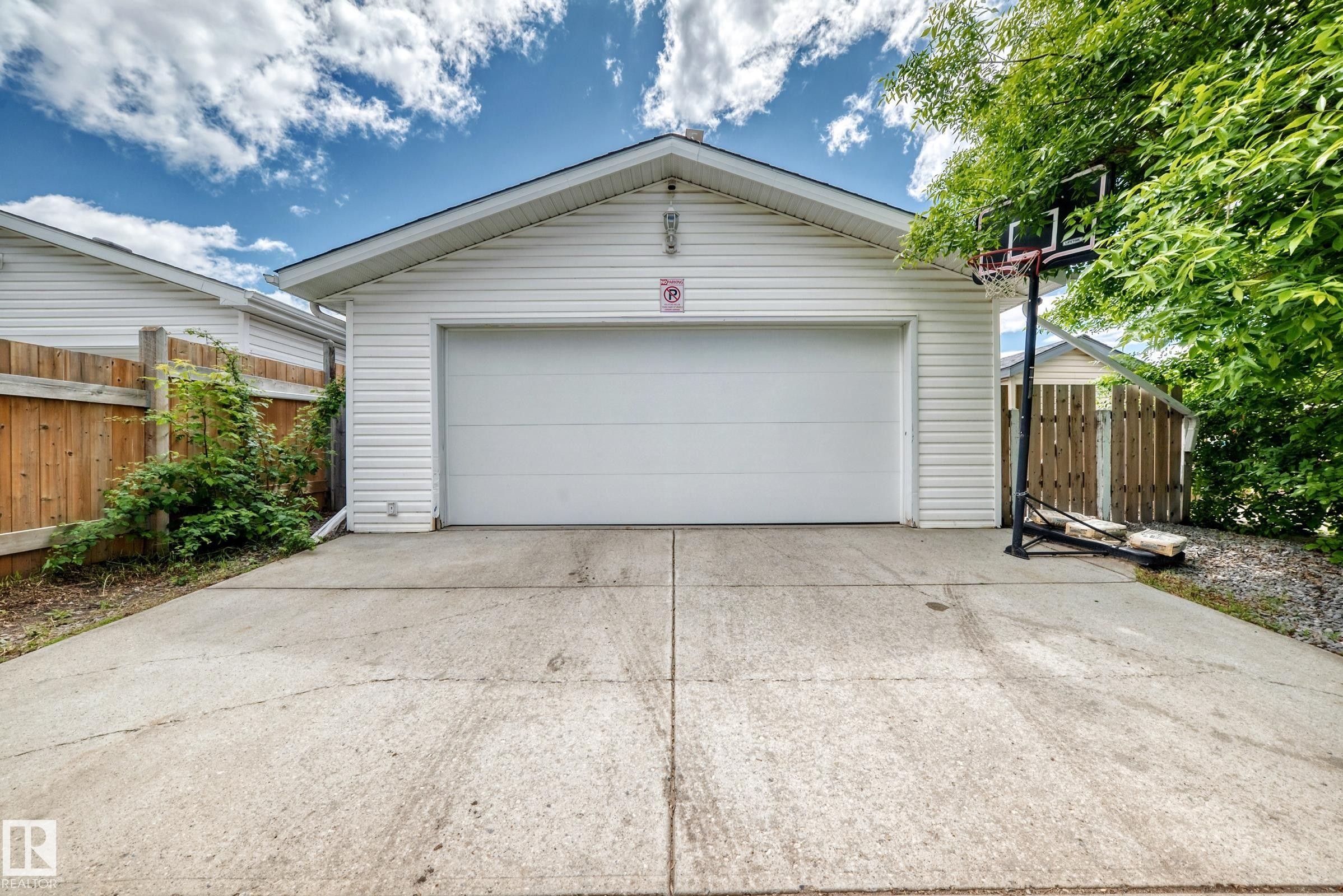 Detached garage featuring white vinyl siding and a white garage door - 5106 19 Avenue, Edmonton, AB