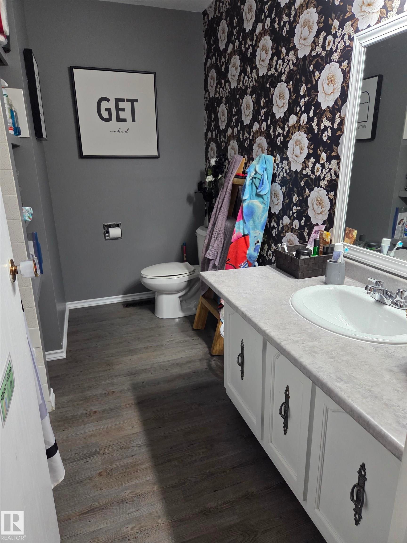 Bathroom featuring a vanity with white cabinetry, a single basin sink, and a gray countertop - 5106 19 Avenue, Edmonton, AB