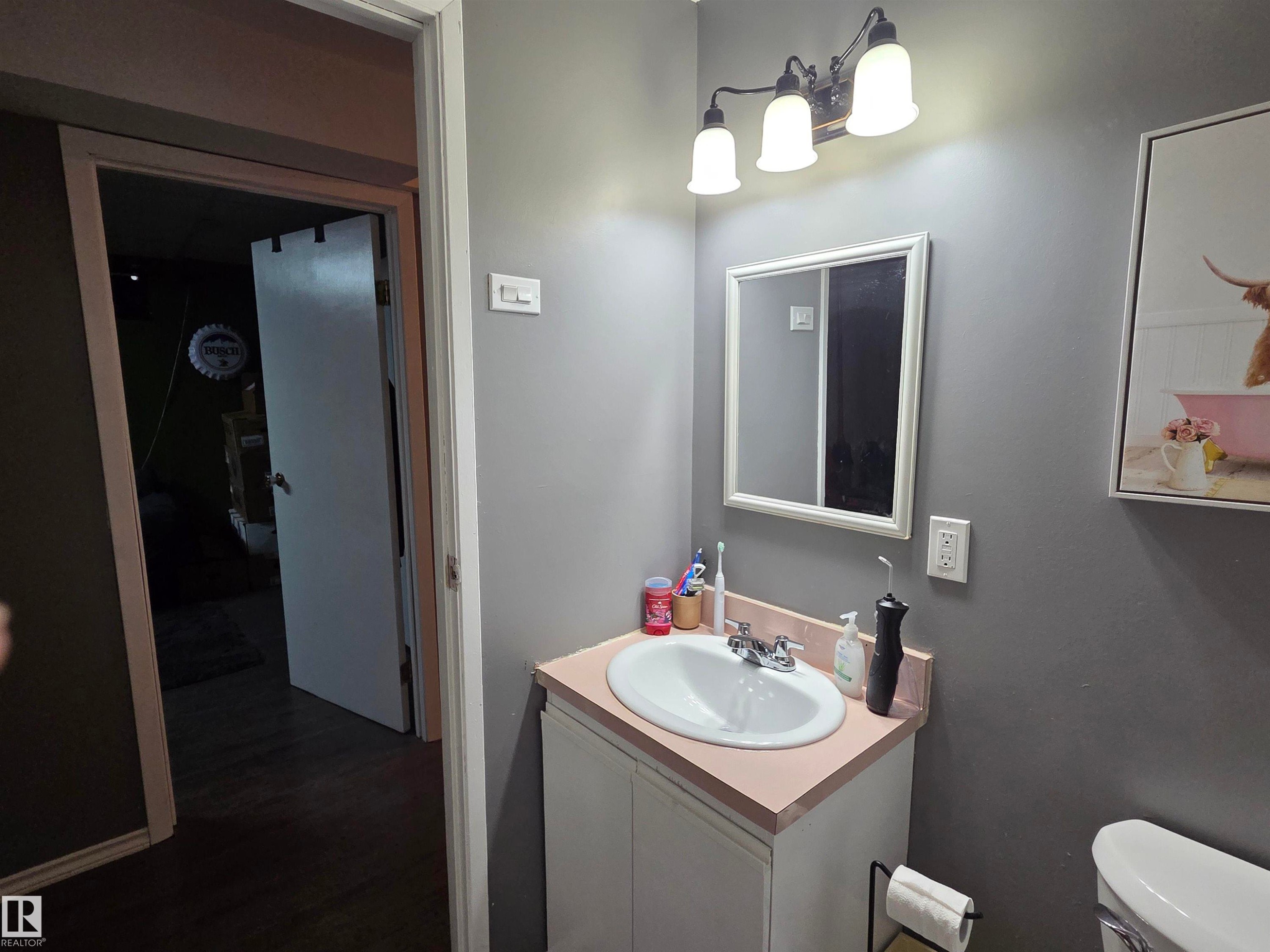 Vanity with integrated sink, chrome faucet, and framed mirror - 5106 19 Avenue, Edmonton, AB