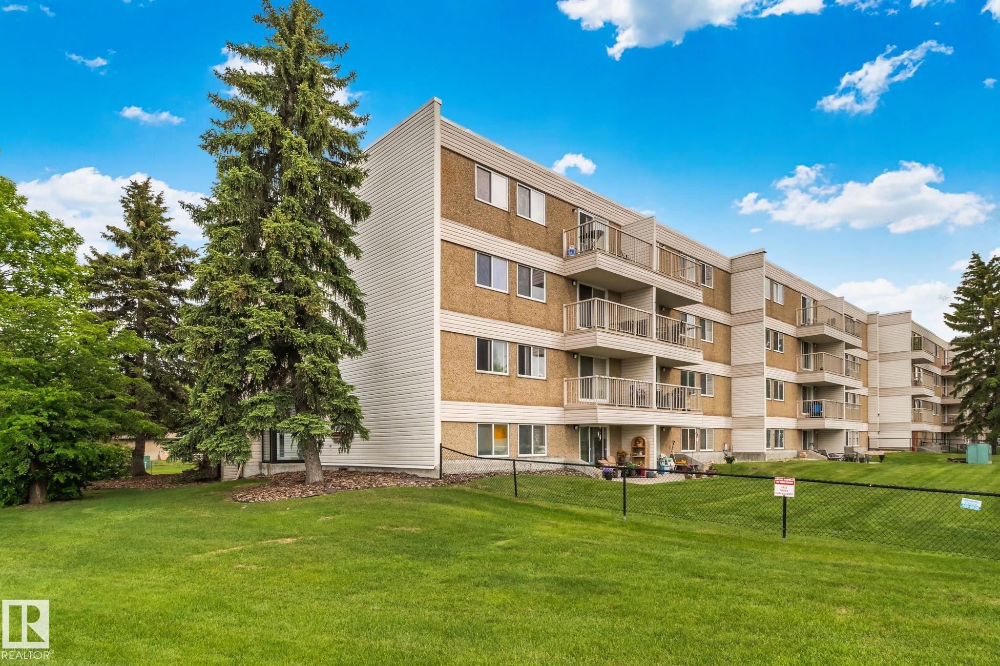 Multi-story residential building featuring balconies with glass railings - 115 4608 52 Avenue, Stony Plain, AB