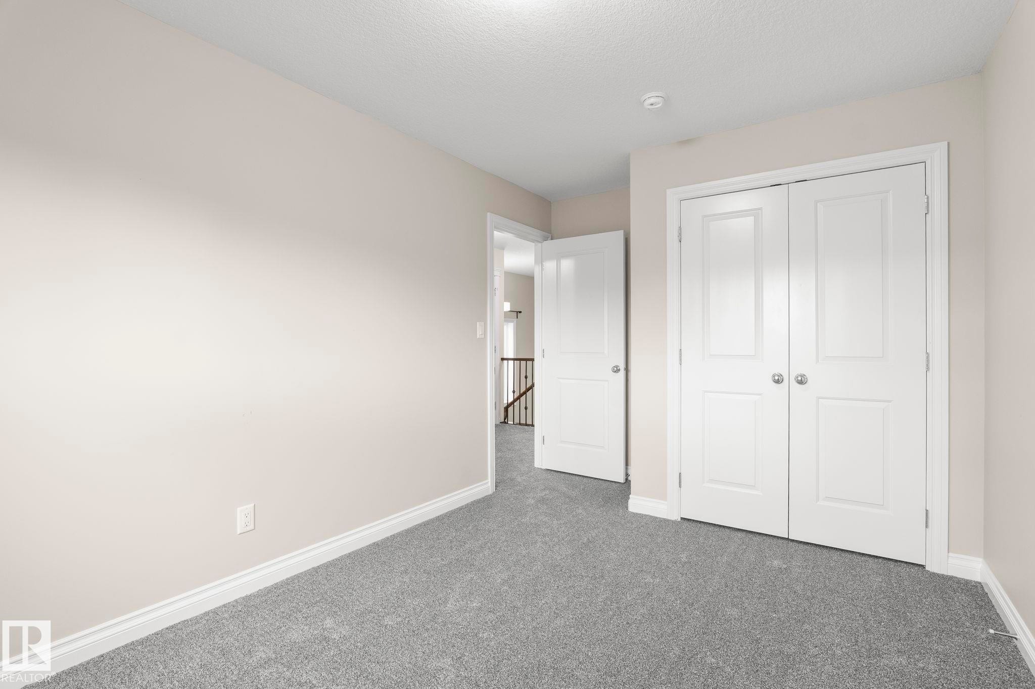 Room featuring light grey carpeting, neutral-toned walls, and white baseboards - 6927 Cardinal Wynd Sw, Edmonton, AB - Indoor Photo Showing Other Room