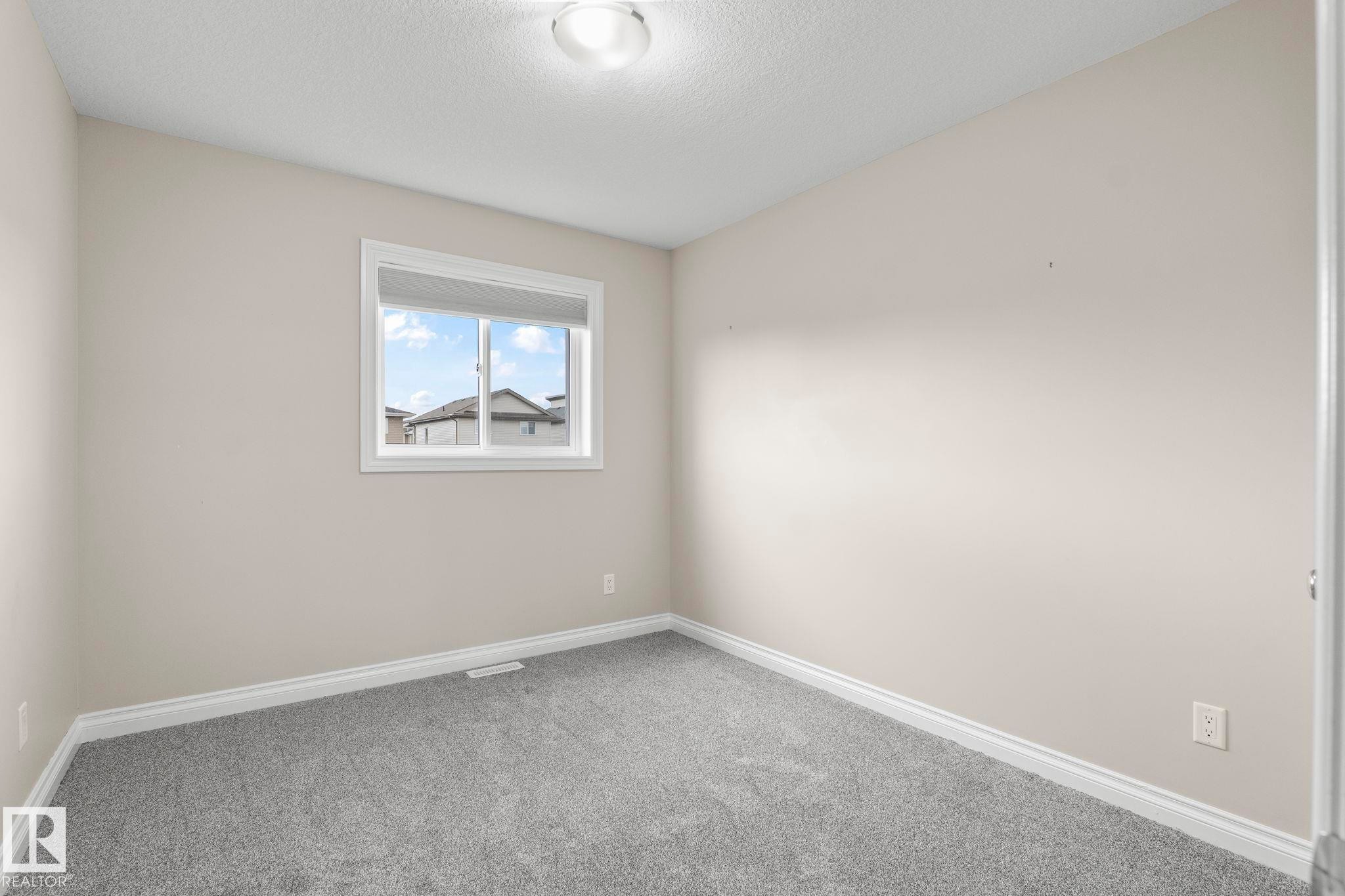 Neutral toned room featuring a single window and plush gray carpeting - 6927 Cardinal Wynd Sw, Edmonton, AB - Indoor Photo Showing Other Room